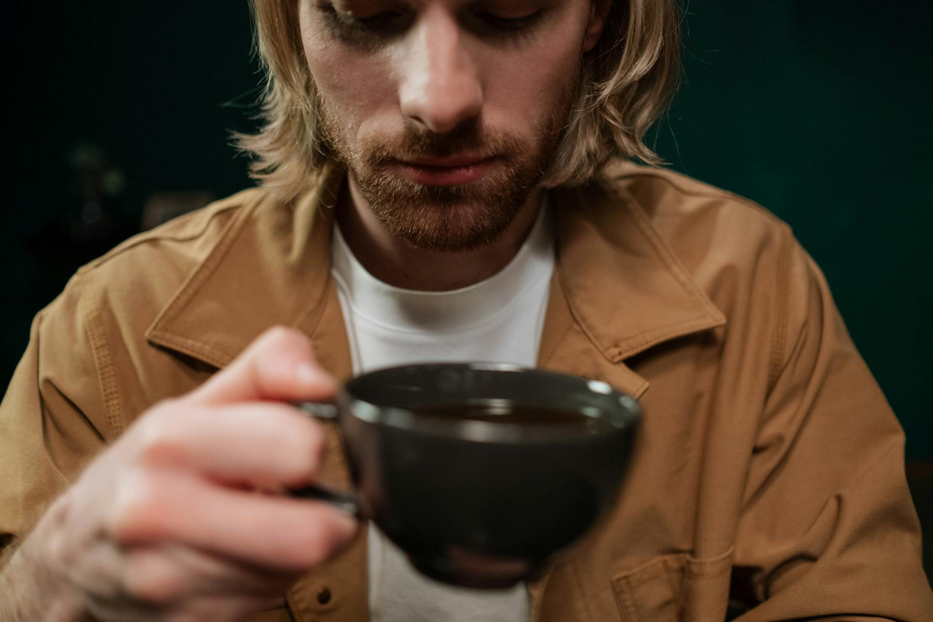 Ein erleichterter Mann mit einer Tasse Kaffee in der Hand | Quelle: Pexels