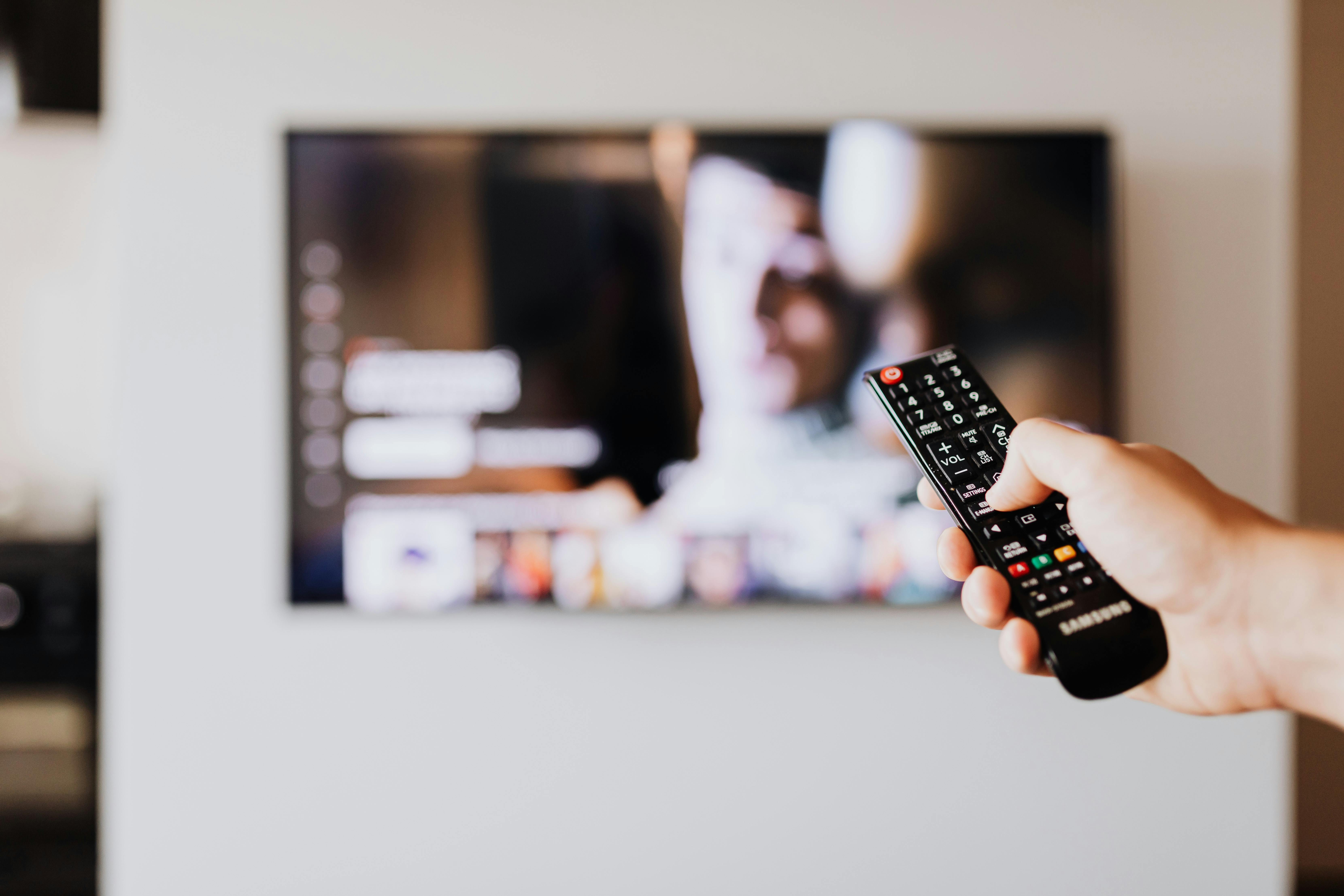 Ein Mann scrollt durch den Fernseher | Quelle: Pexels