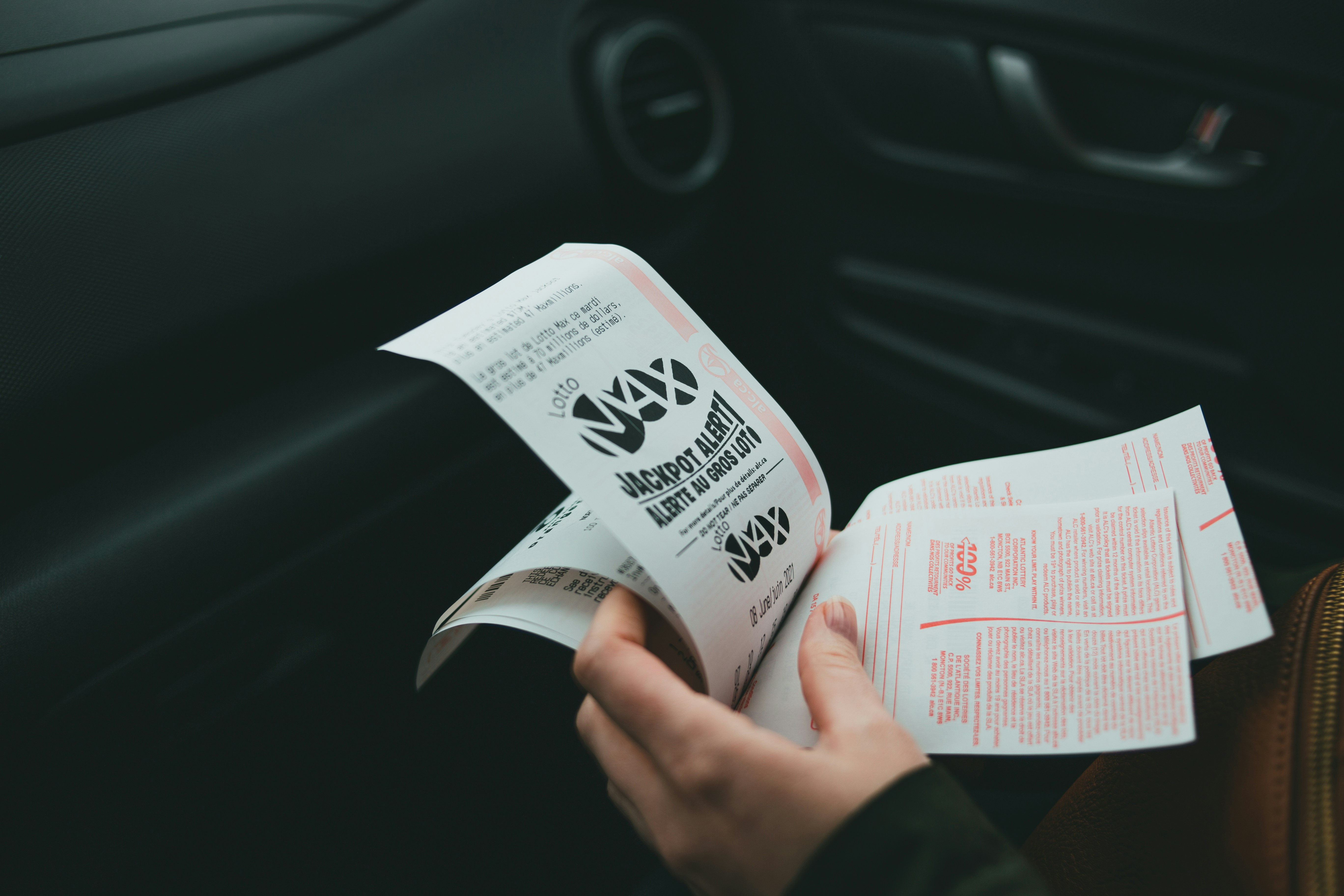 Eine Person mit Lottoscheinen | Quelle: Unsplash