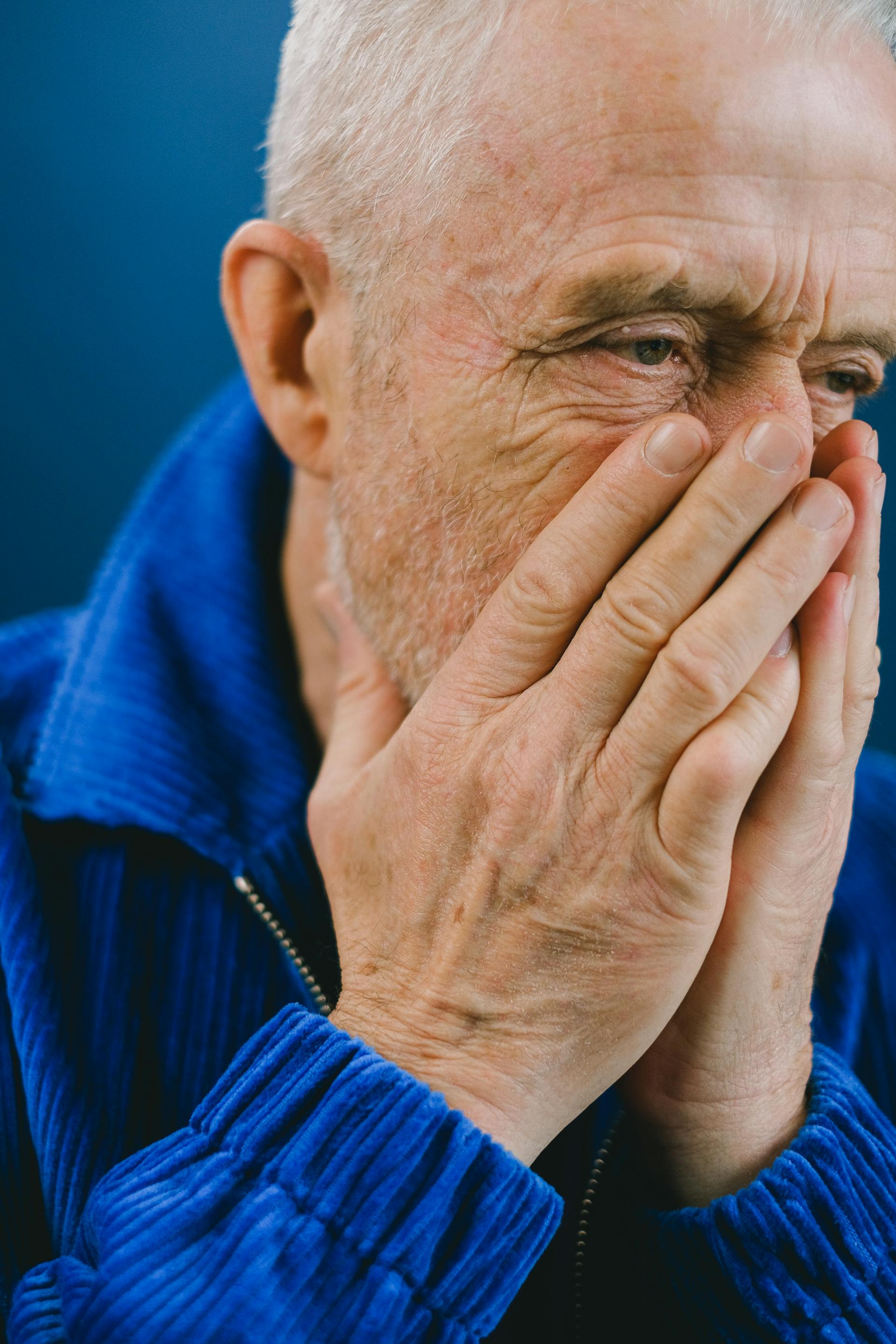 Ein aufgebrachter älterer Mann, der sich den Mund zuhält | Quelle: Pexels