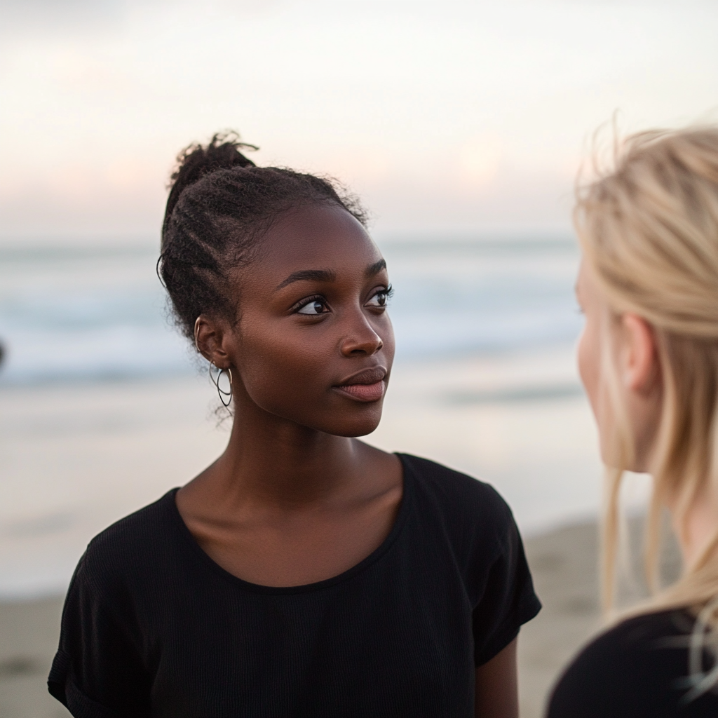 Zwei Frauen unterhalten sich am Strand | Quelle: Midjourney