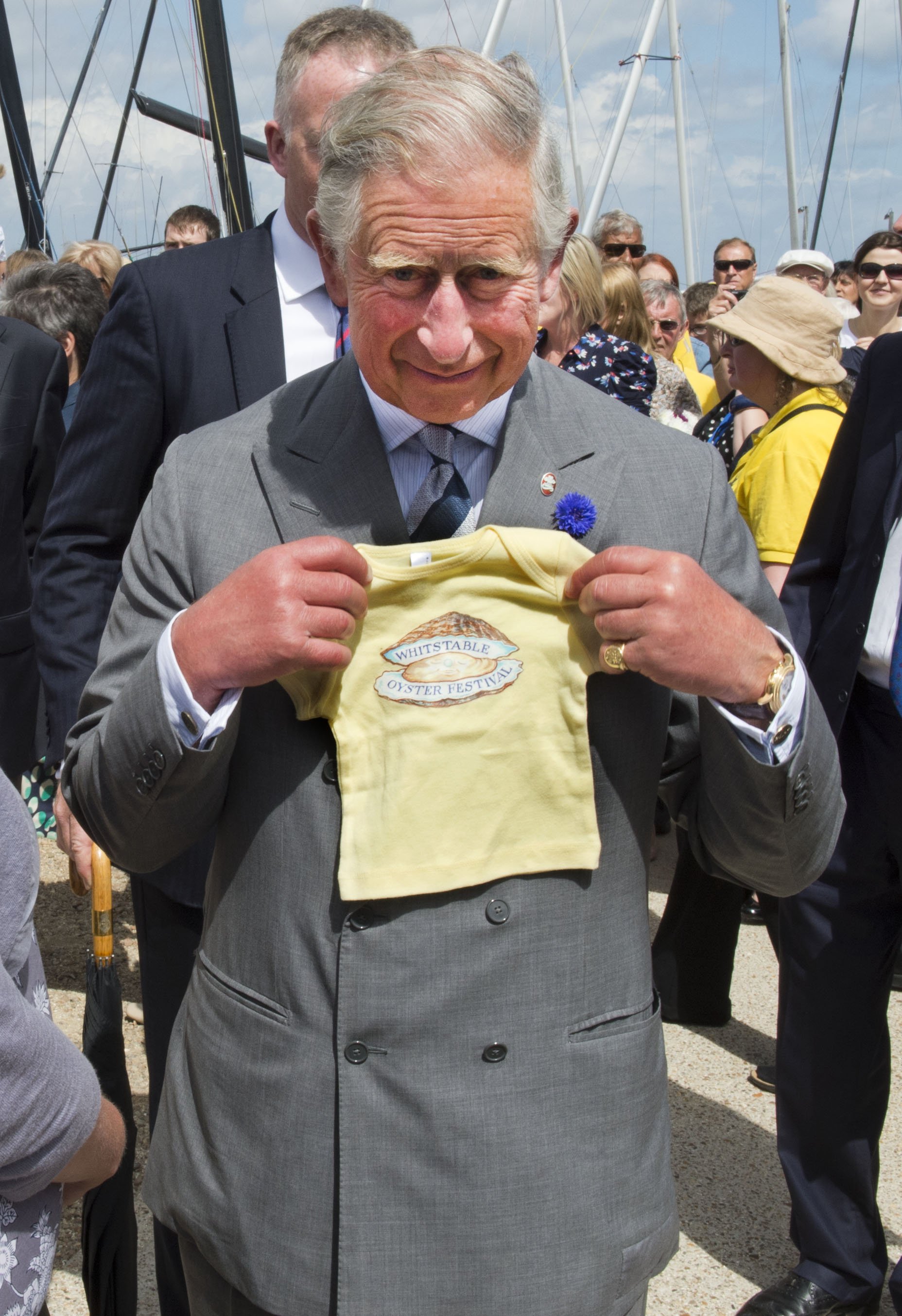 König Charles wird mit einem Geschenk für seinen Enkel Prinz George von Cambridge während eines Besuchs beim Whitstable Oyster Festival am 29. Juli 2013 im Hafen von Whitstable, Whitstable, Kent, gesehen. | Quelle: Getty Images
