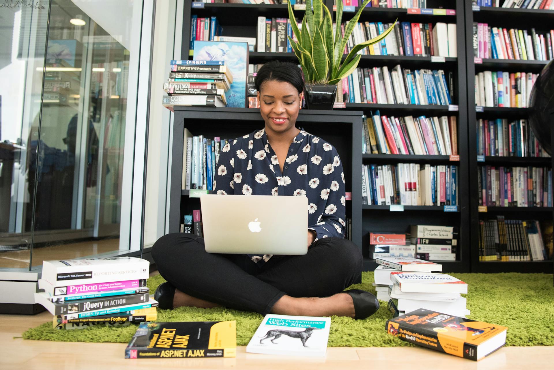 Eine Frau, die in einer Bibliothek auf ihrem Laptop sitzt | Quelle: Pexels