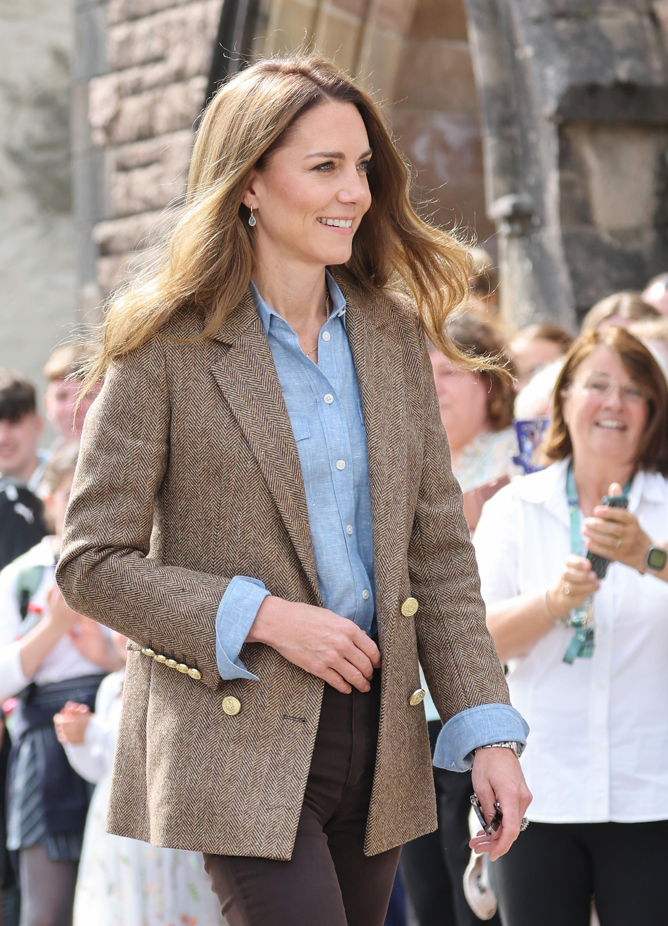 Catherine spaziert mit einem sanften Lächeln durch Tobermory, umgeben von Gratulanten. Ihr Aussehen - einschließlich ihres braunen Tweed-Blazers und ihres blauen Hemdes - erregte während des königlichen Besuchs viel Aufmerksamkeit.