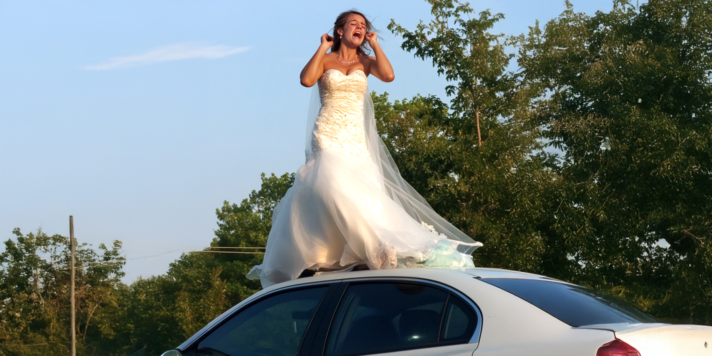 Eine Frau in einem Hochzeitskleid, die weinend auf dem Dach eines Autos steht | Quelle: Amomama