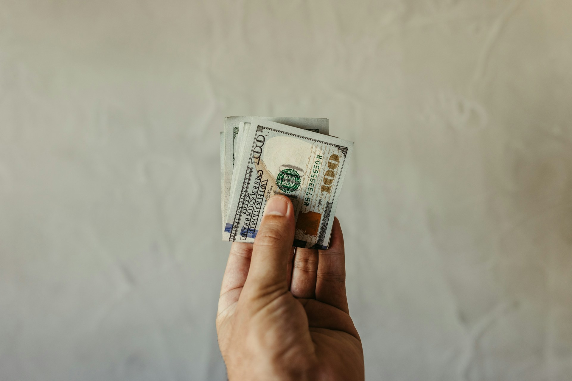 Ein Mann mit Dollarscheinen in der Hand | Quelle: Unsplash