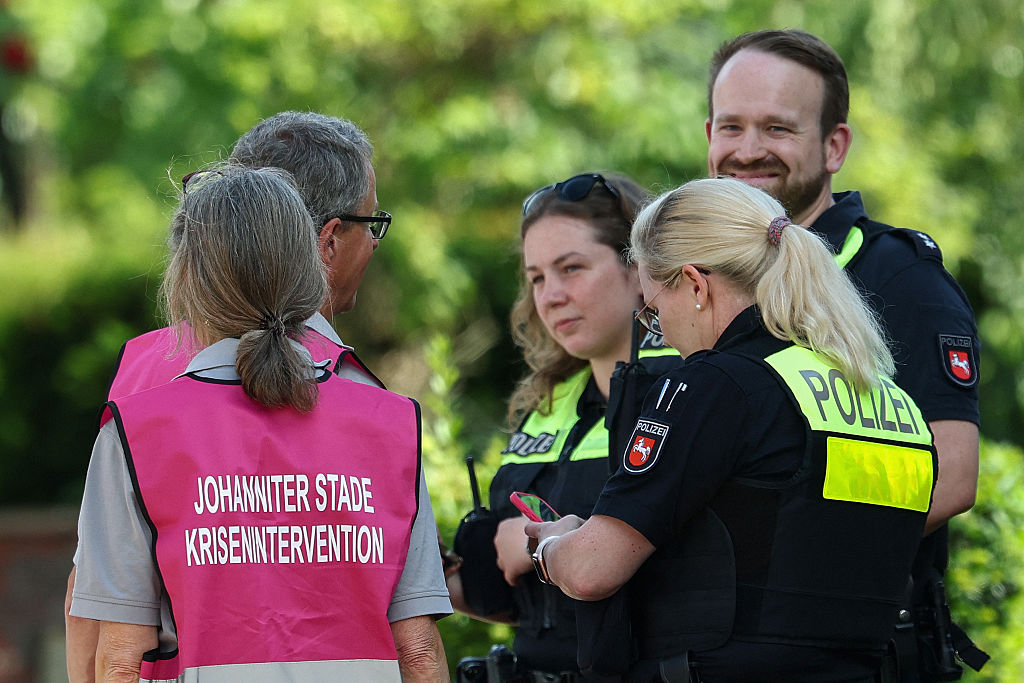 Polizisten sprechen mit Mitgliedern eines Kriseninterventionsteams in der Nähe des Tatorts, an dem am 29. Juni 2026 bei einer Schießerei in Stade, einer Stadt im Norden Deutschlands etwa 50 Kilometer westlich von Hamburg, fünf Menschen getötet wurden. | Quelle: Getty Images