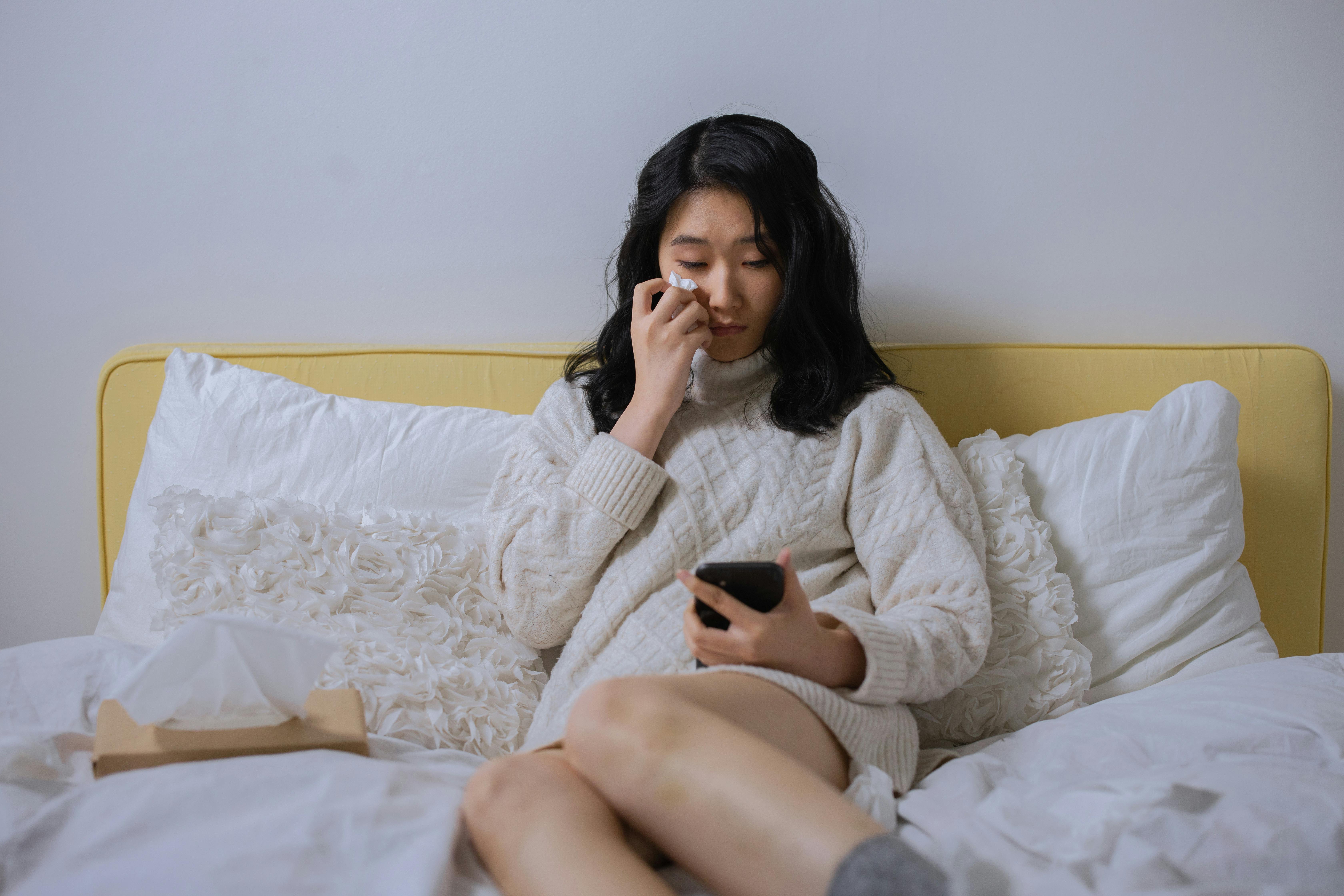 Eine weinende Frau, die auf ihr Handy schaut | Quelle: Pexels