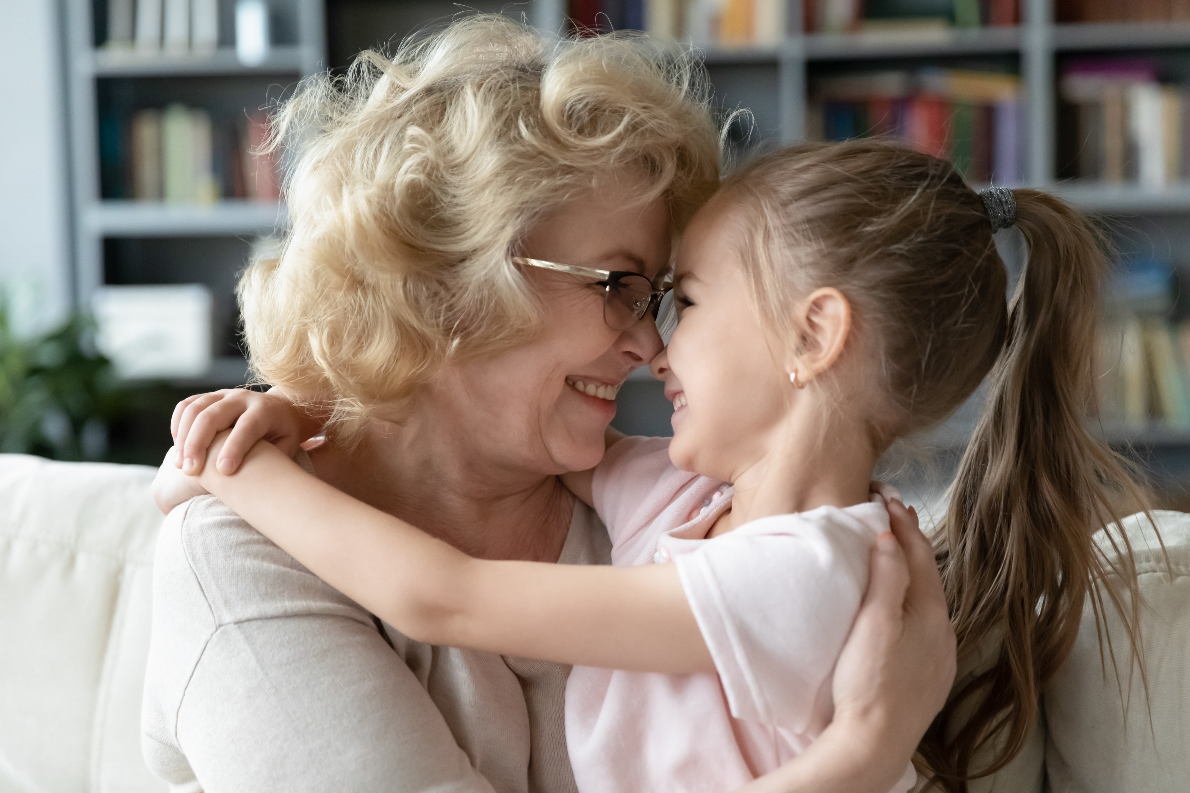 Eine glückliche Großmutter, die ihre kleine Enkelin umarmt | Quelle: Shutterstock
