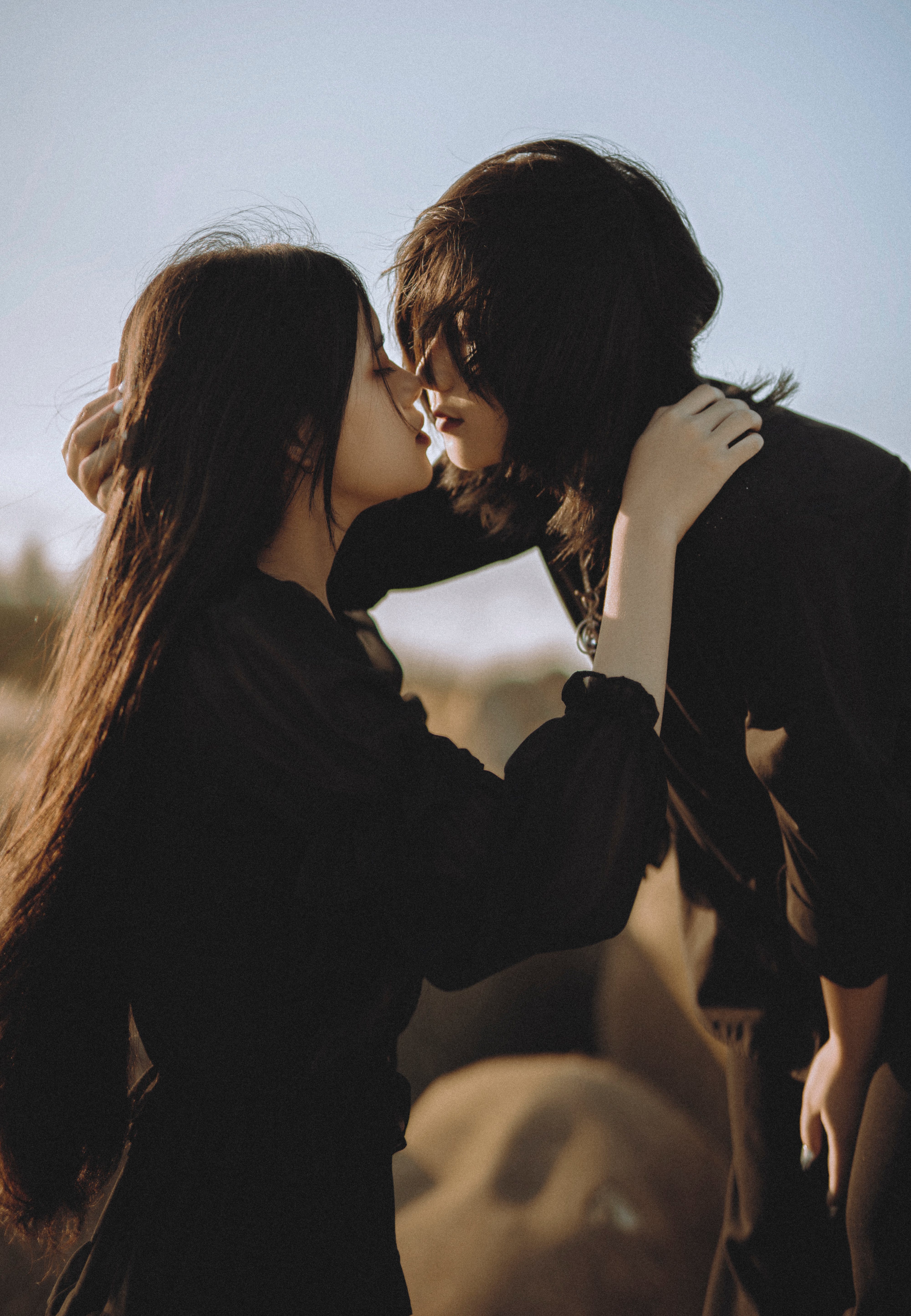 Ein Paar, das sich für einen Kuss zueinander neigt | Quelle: Pexels