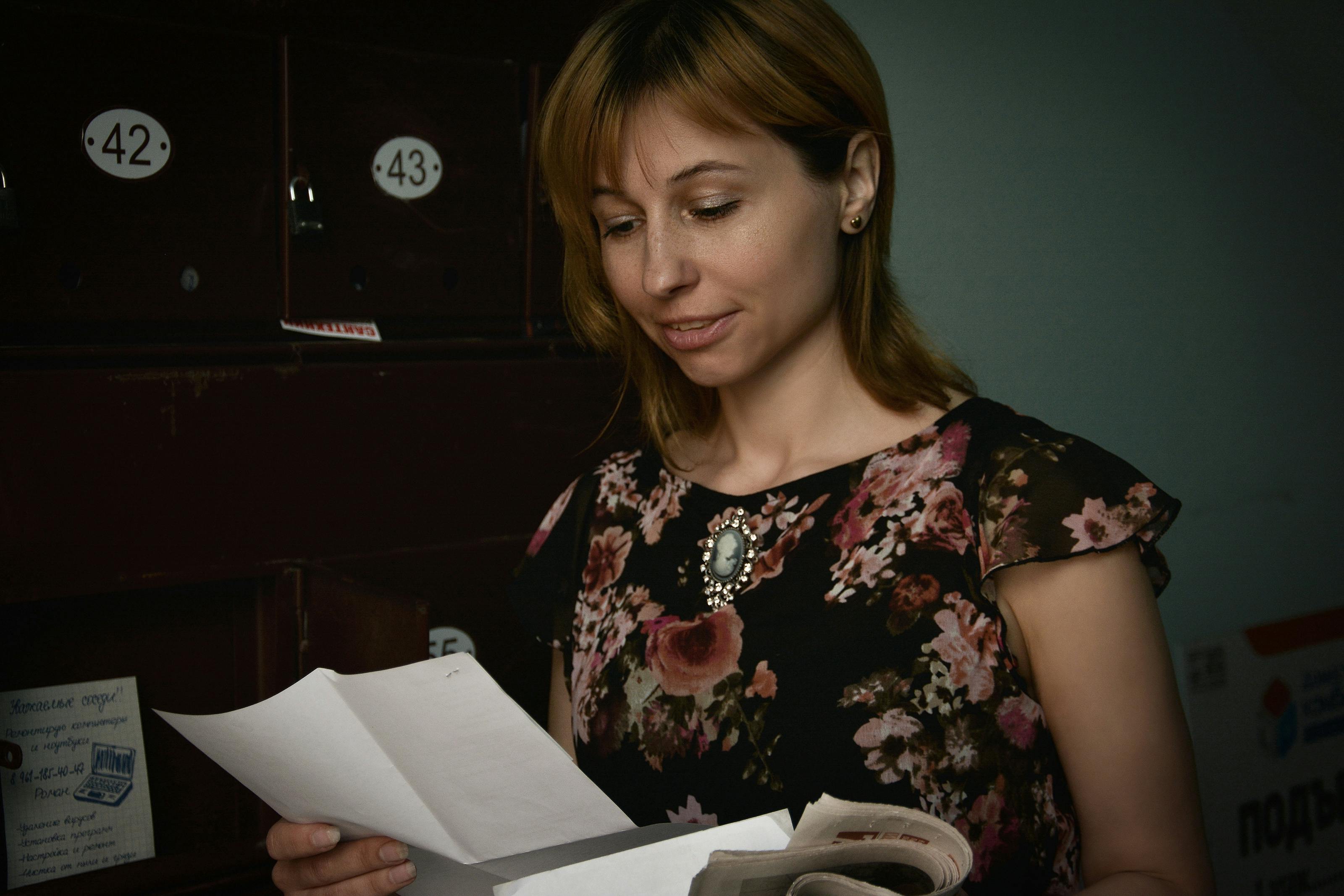 Eine Frau steht und liest einen Brief | Quelle: Pexels