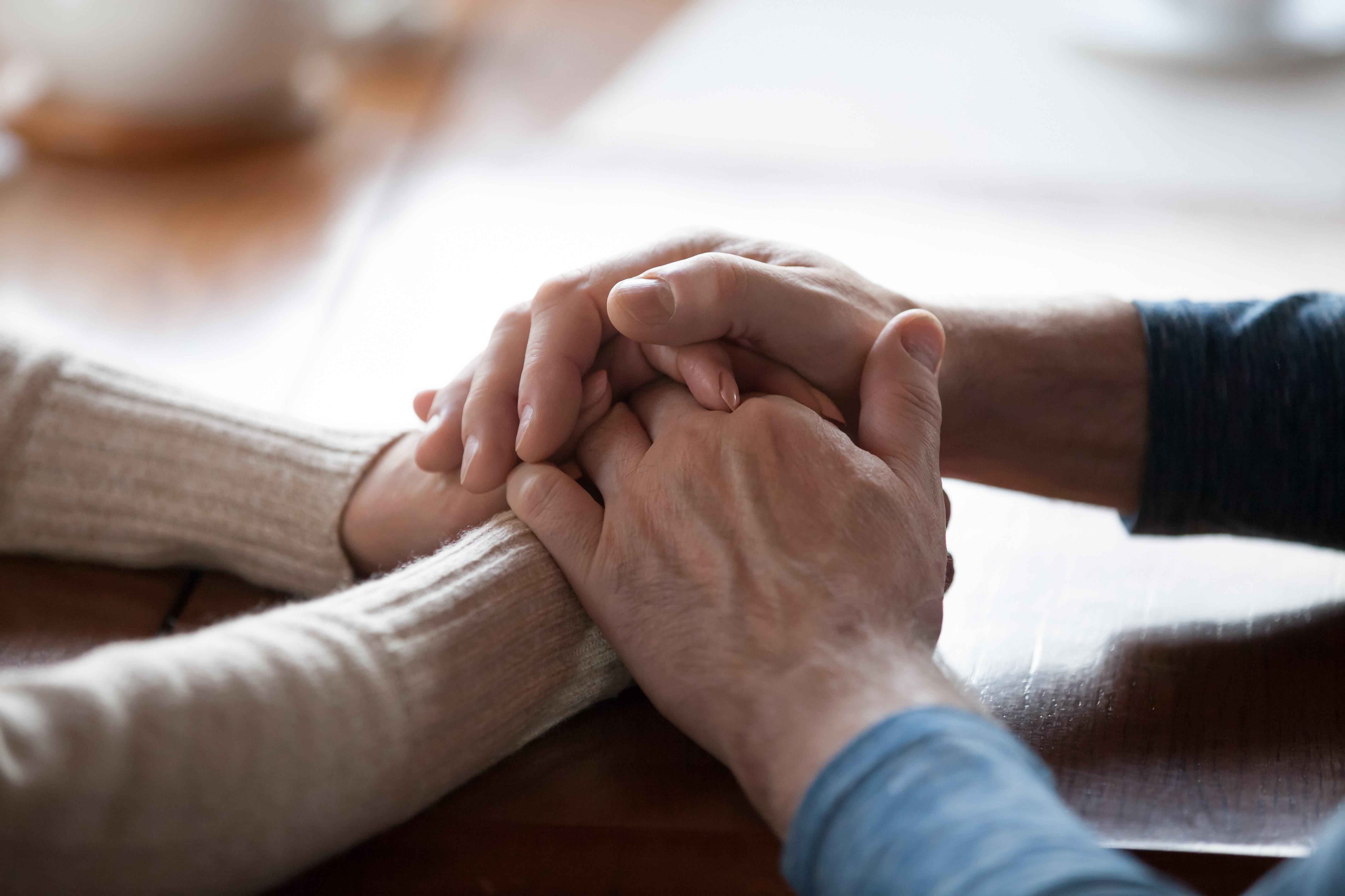 Ein Paar, das sich an den Händen hält, als Geste der Unterstützung | Quelle: Shutterstock