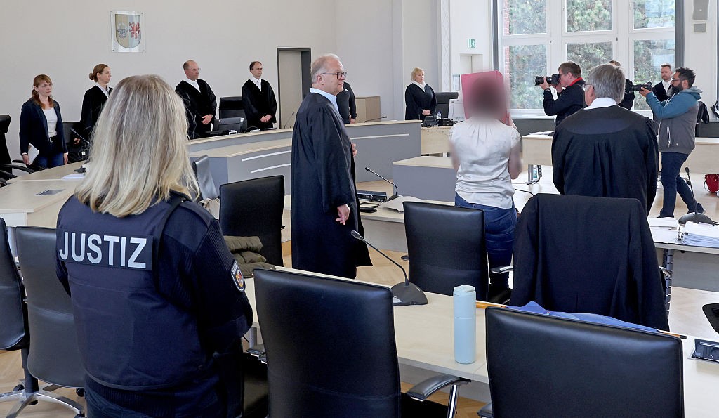13. Mai 2026, Mecklenburg-Vorpommern, Rostock: Ein Gerichtsangestellter (v. l. n. r.), Rechtsanwalt Thomas Löcker, der Angeklagte und Rechtsanwalt Andreas Ohm stehen zu Beginn der Fortsetzung des Mordprozesses im Gerichtssaal des Landgerichts | Quelle: Getty Images