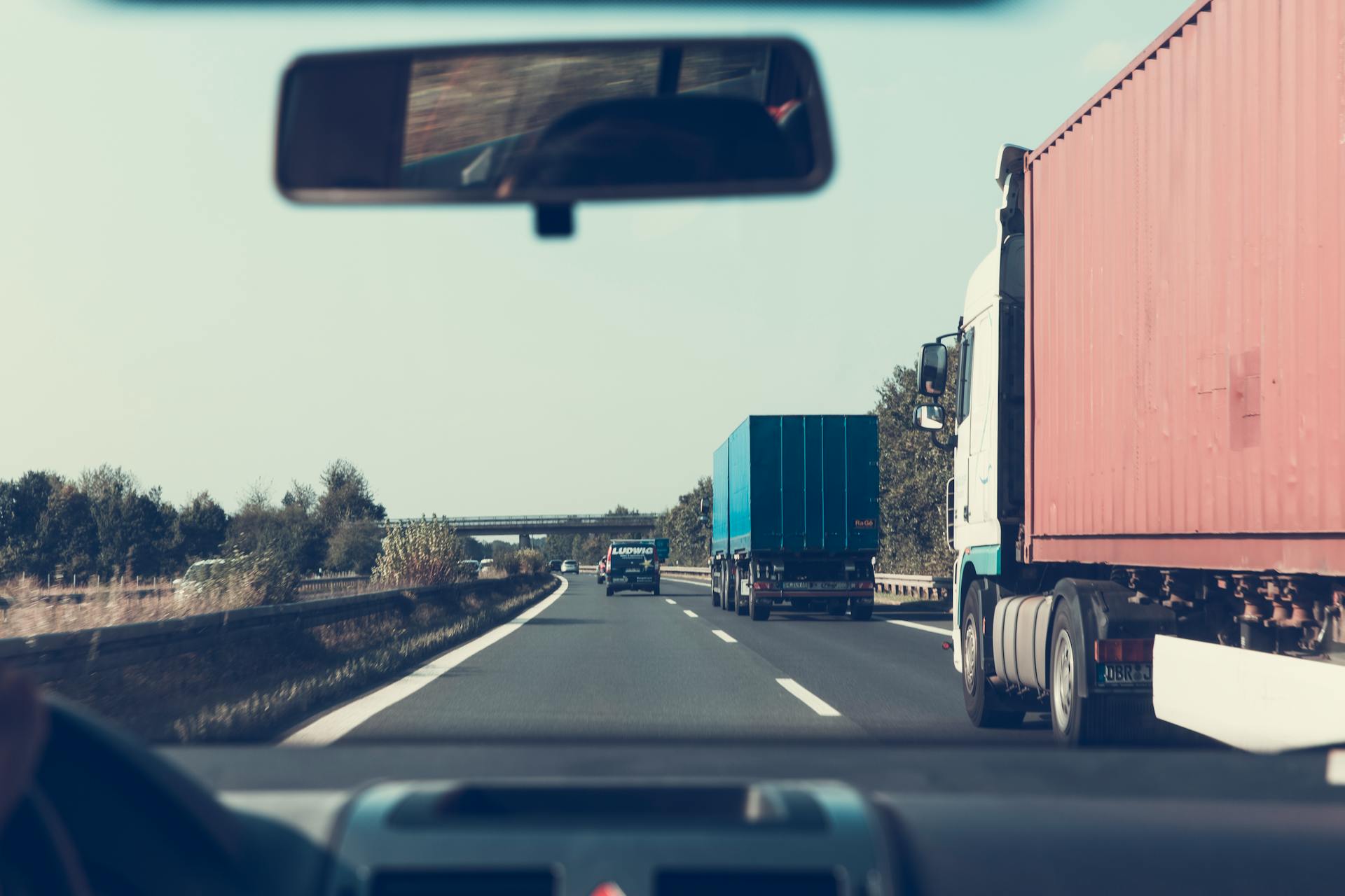 Blaue und rote Lastwagen auf einer Autobahn | Quelle: Pexels