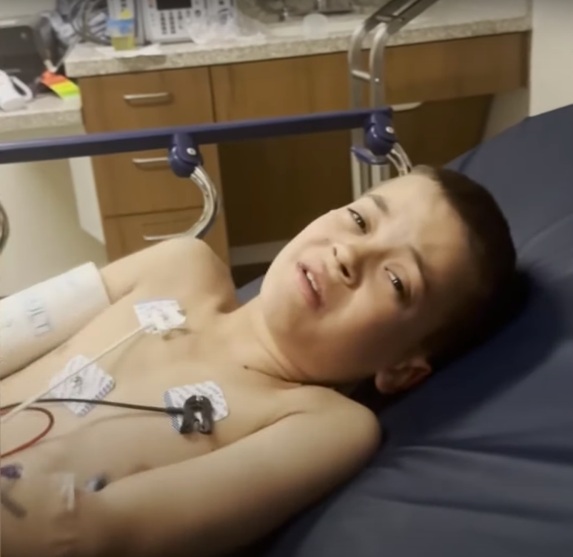 Liam Dahlberg krümmt sich vor Schmerzen in einem Krankenhausbett. | Quelle: YouTube/WTHR