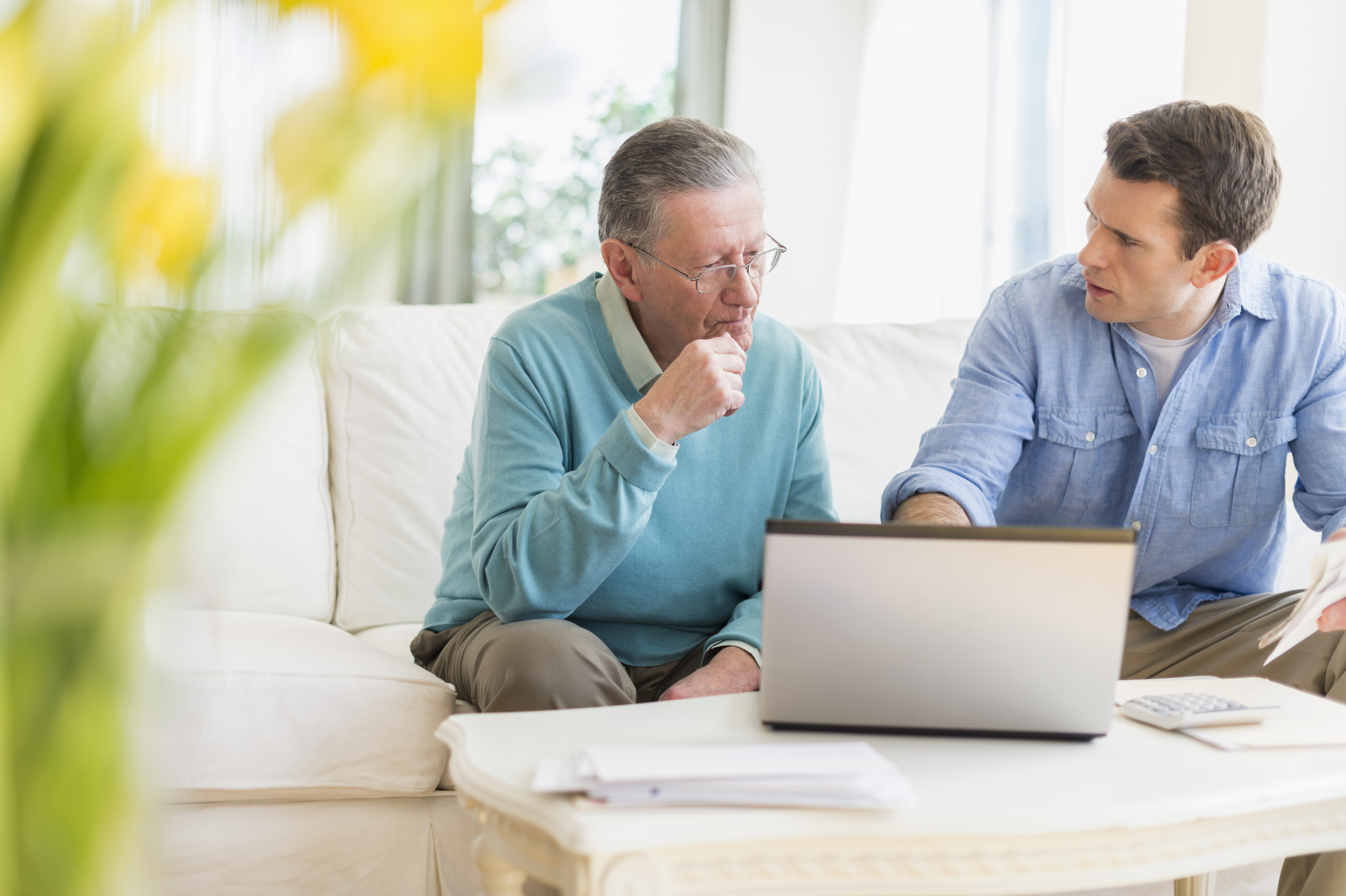 Ein Vater und sein Sohn diskutieren etwas mit aufgeklapptem Laptop | Quelle: Getty Images