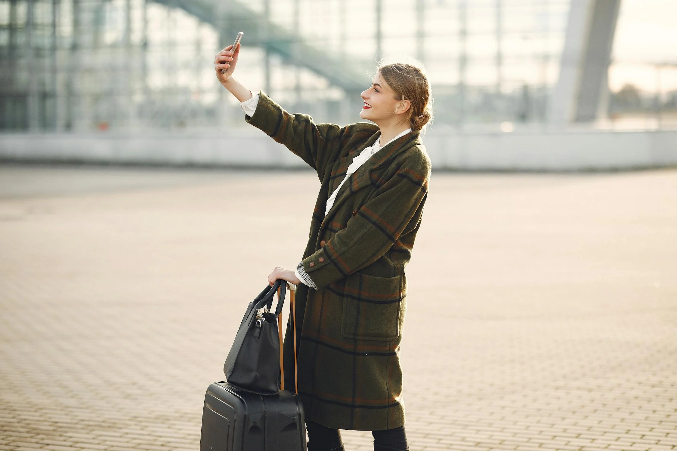 Eine Frau mit ihrem Telefon in einem Flughafen | Quelle: Pexels