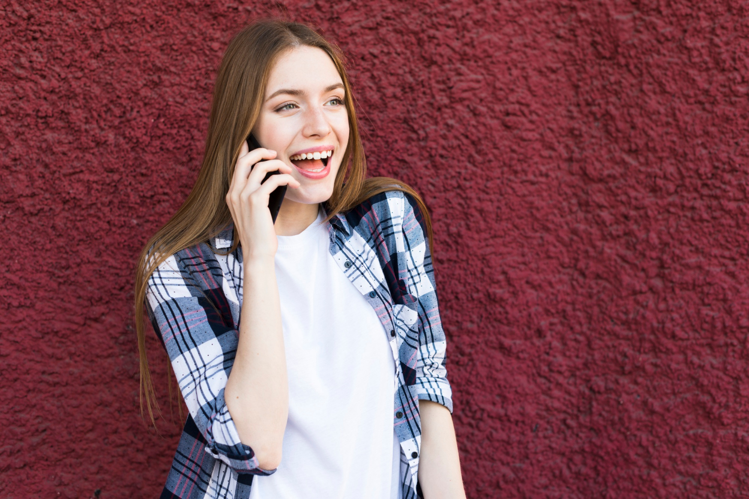 Eine Frau, die lacht, während sie telefoniert | Quelle: Freepik