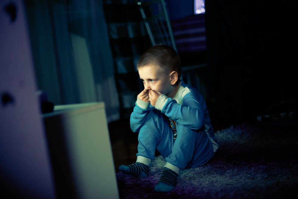 Ein trauriger kleiner Junge, der Angst vor der Dunkelheit hat und fernsieht. | Quele: Shutterstock