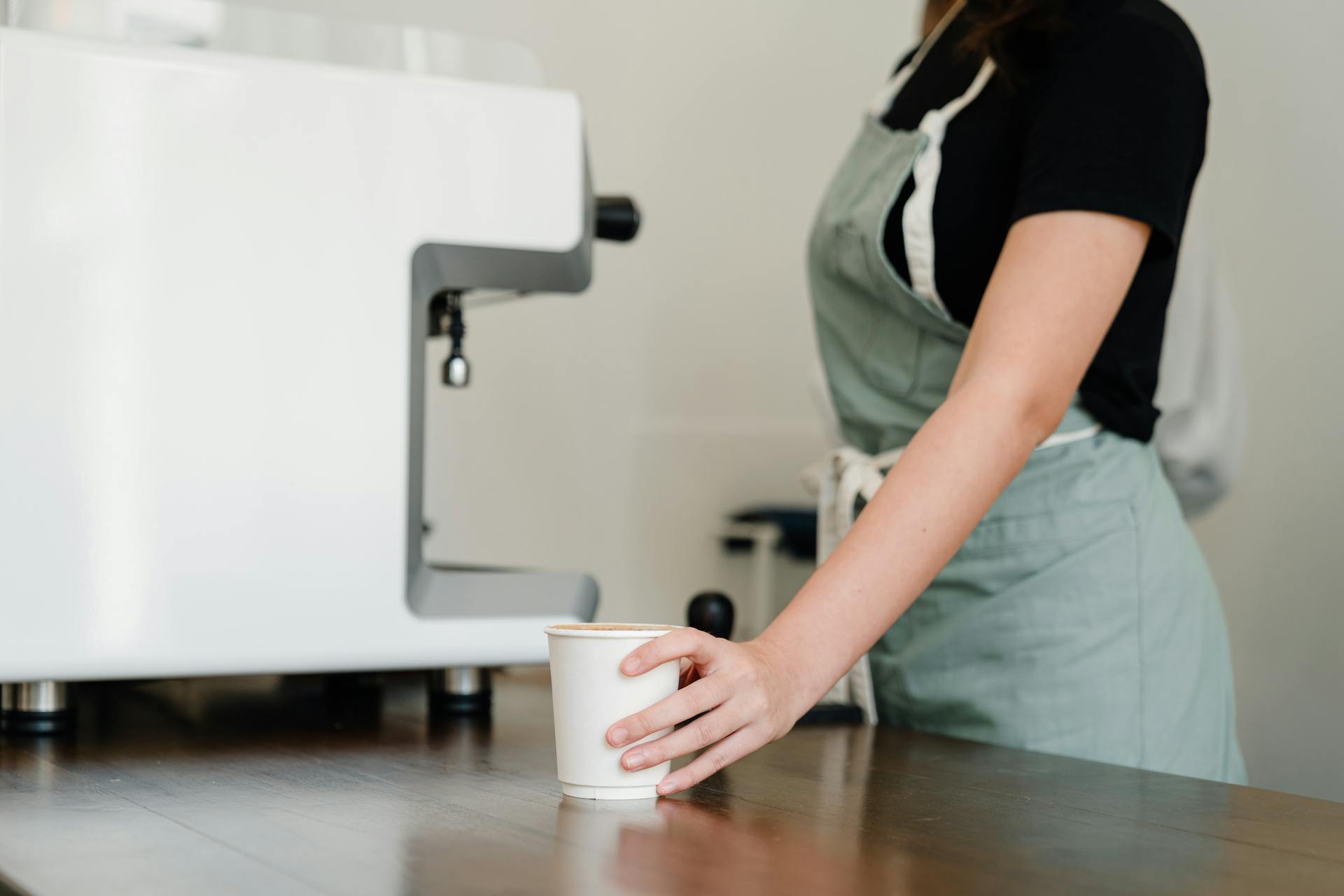 Ausgeschnittene Nahaufnahme einer Kellnerin mit einer Kaffeetasse | Quelle: Pexels