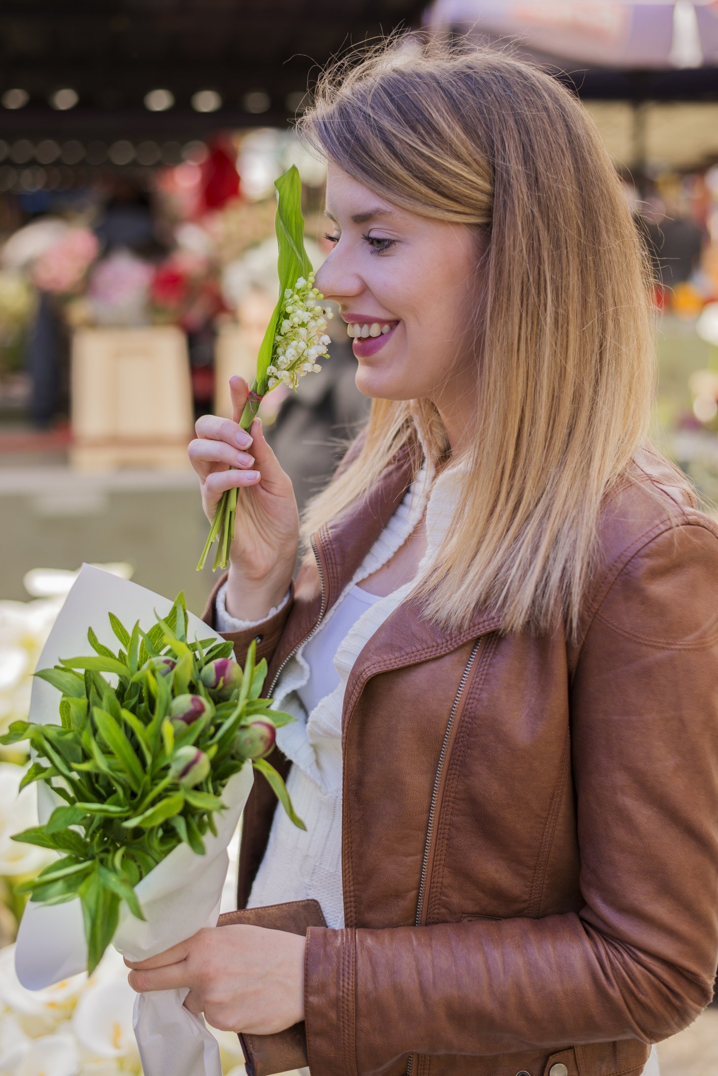 Frau riecht nach Lilie und kauft Blumen auf dem Markt I Quelle: Getty Images
