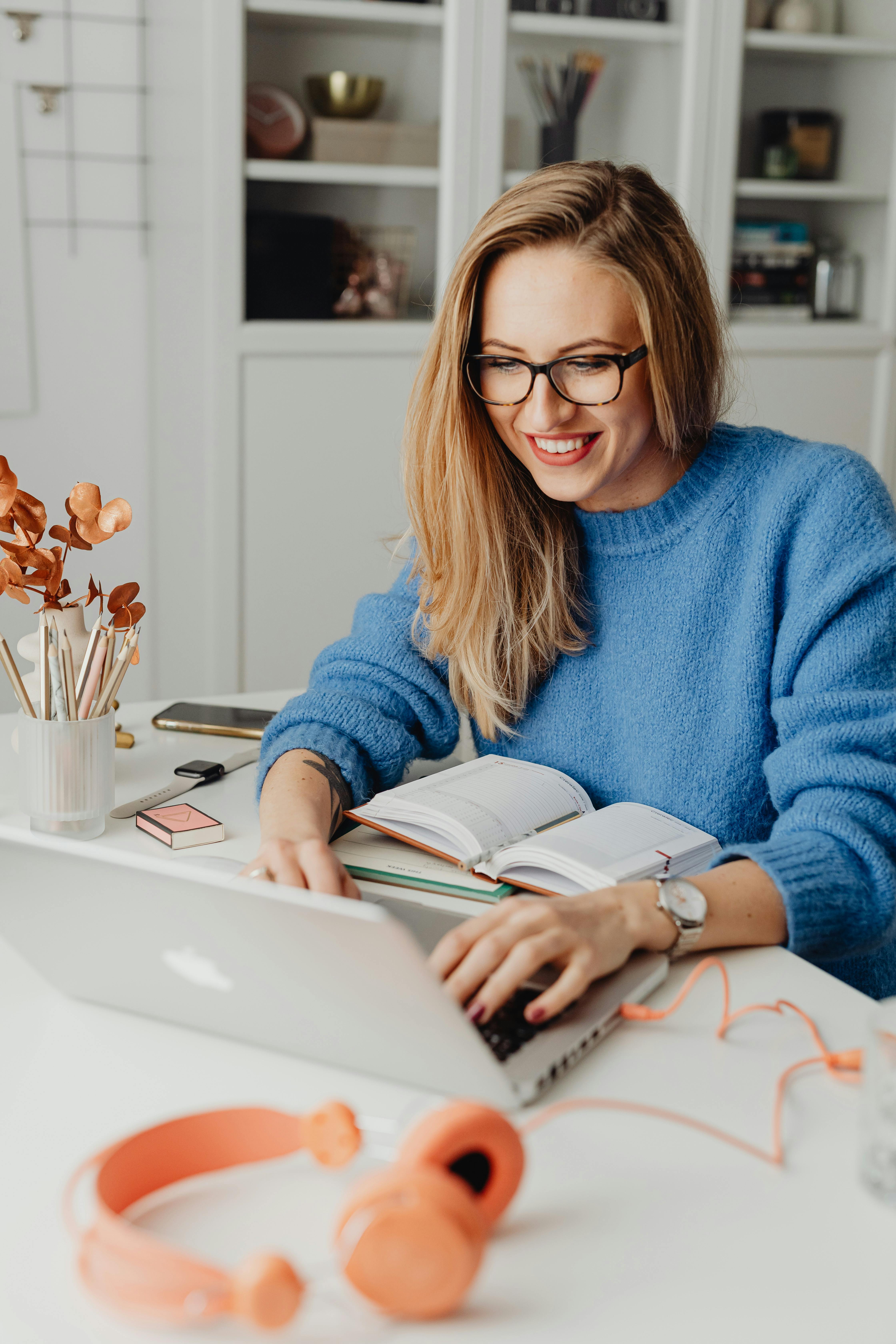 Eine glückliche Frau, die einen Laptop benutzt | Quelle: Pexels