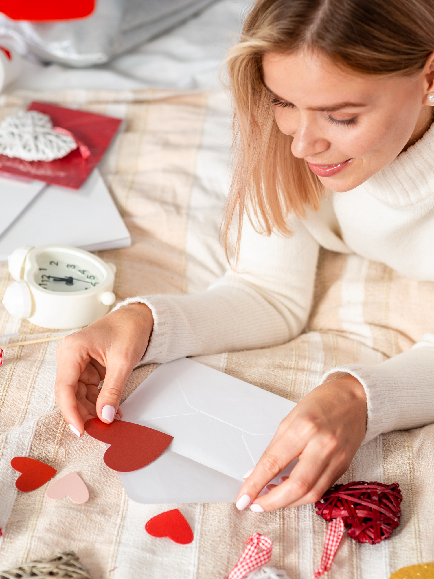 Eine Frau legt ein herzförmiges Stück Papier in einen Umschlag | Quelle: Freepik