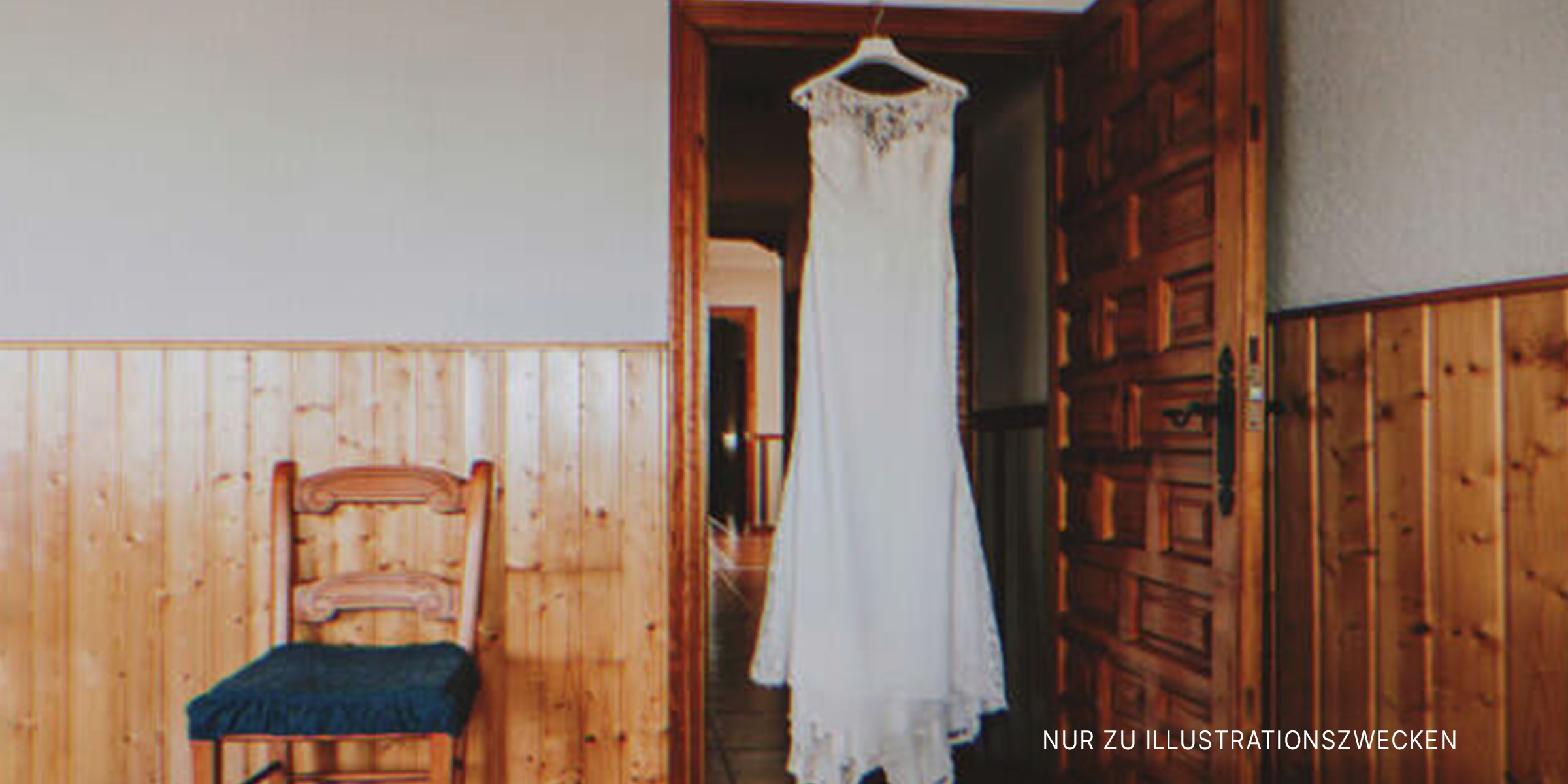 Das Hochzeitskleid hängt in der Tür. | Quelle: Shutterstock