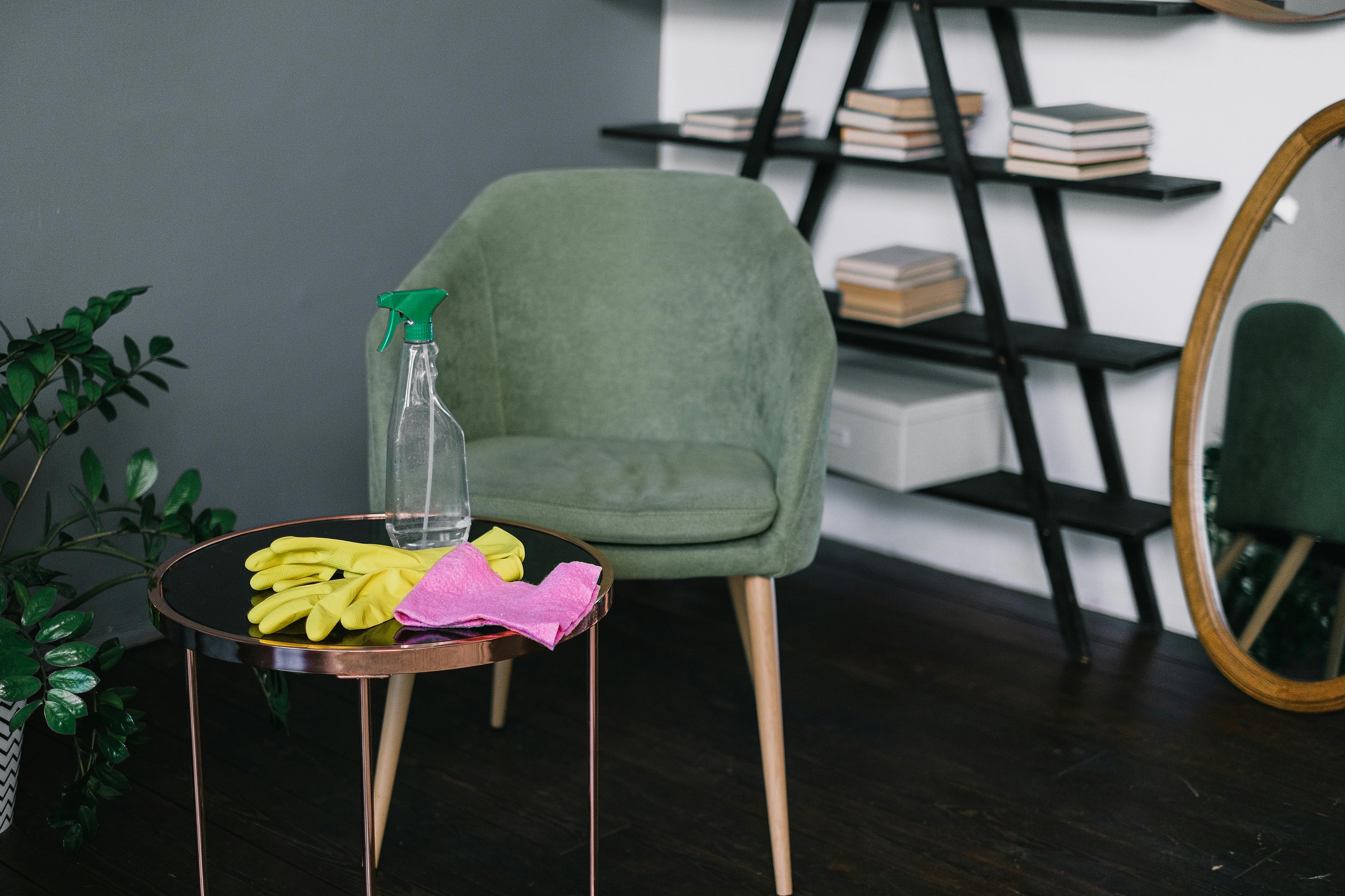 Ein Stuhl mit einem Spray, einem Tuch und Handschuhen in der Nähe | Quelle: Pexels