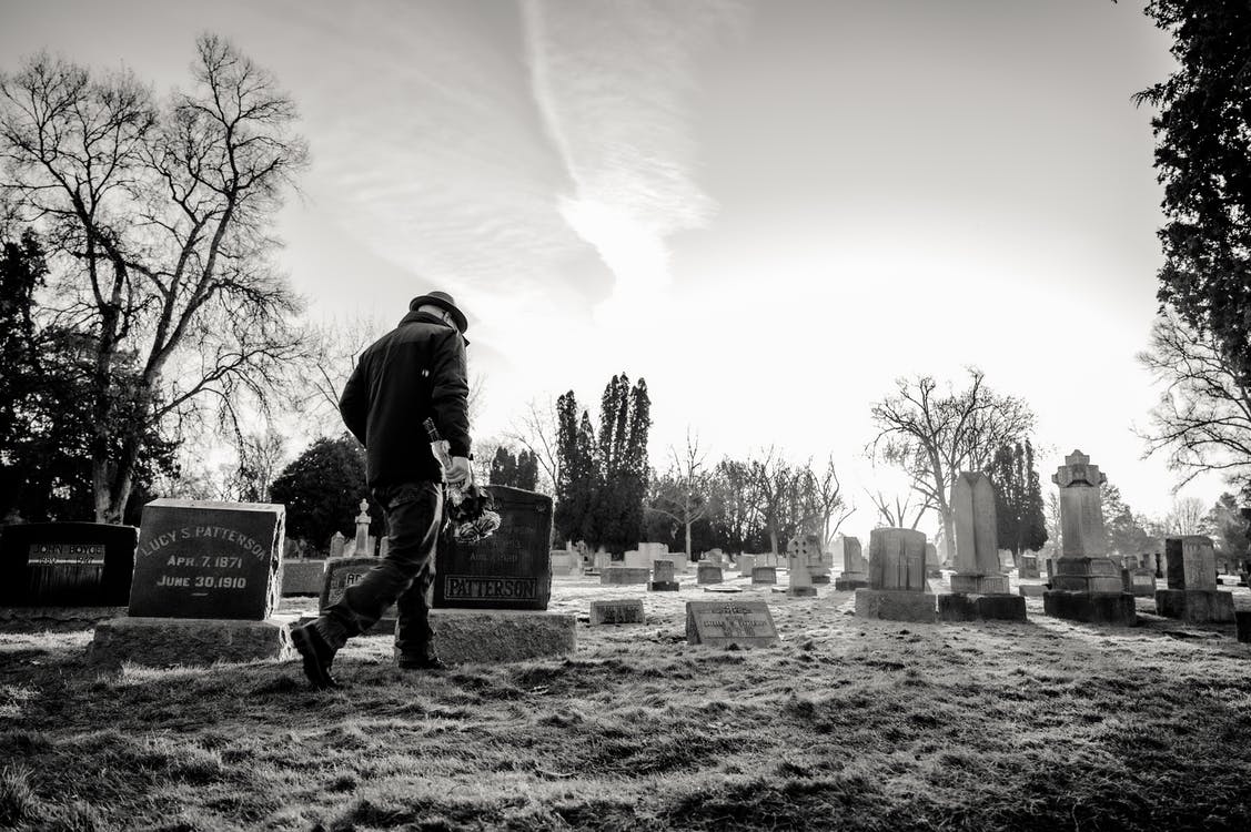 Ein Mann stand über dem Grab von Herrn Hammer und hielt das Schild. | Quelle: Pexels