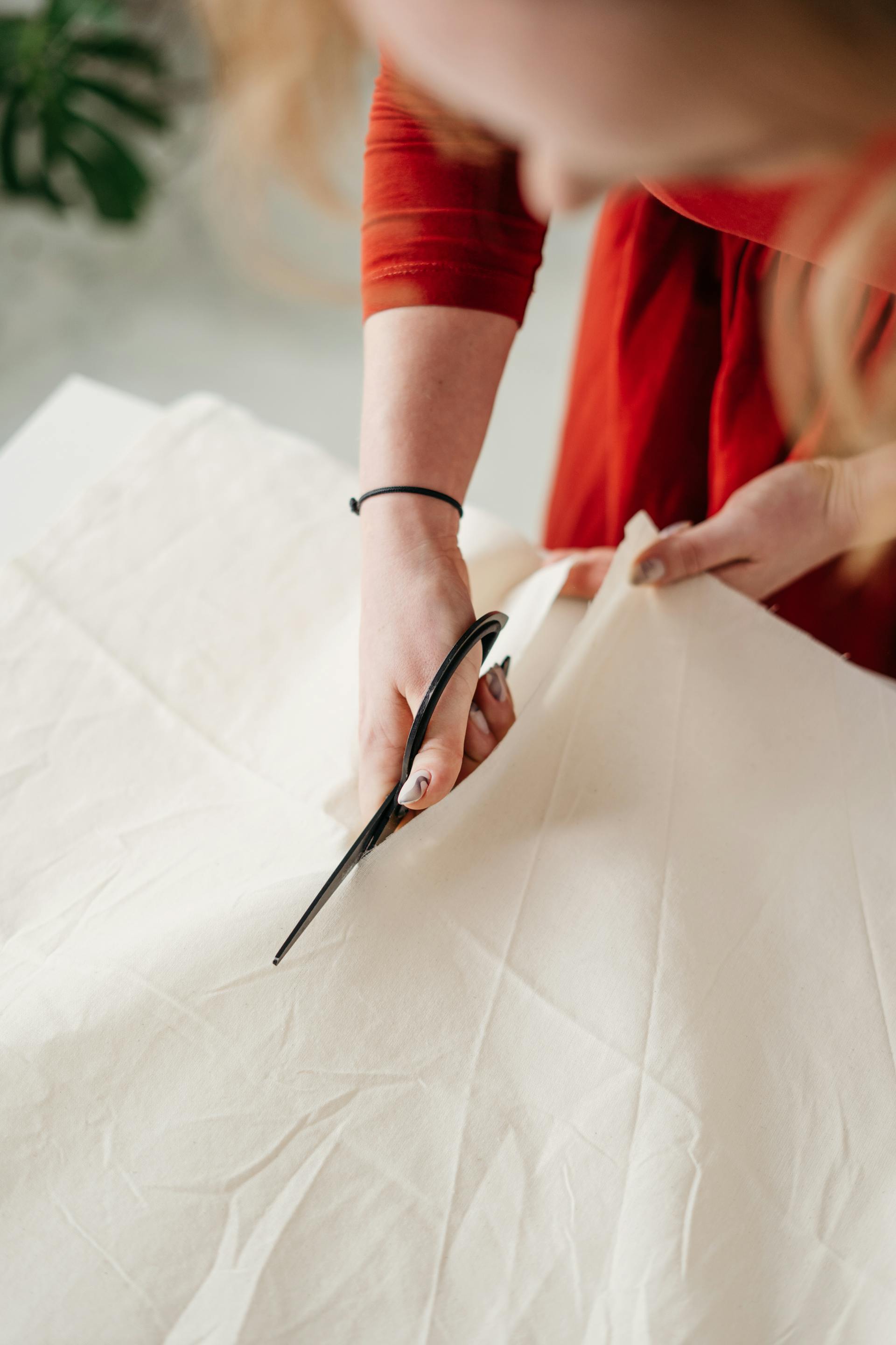 Eine Frau, die ein Kleid zuschneidet | Quelle: Pexels