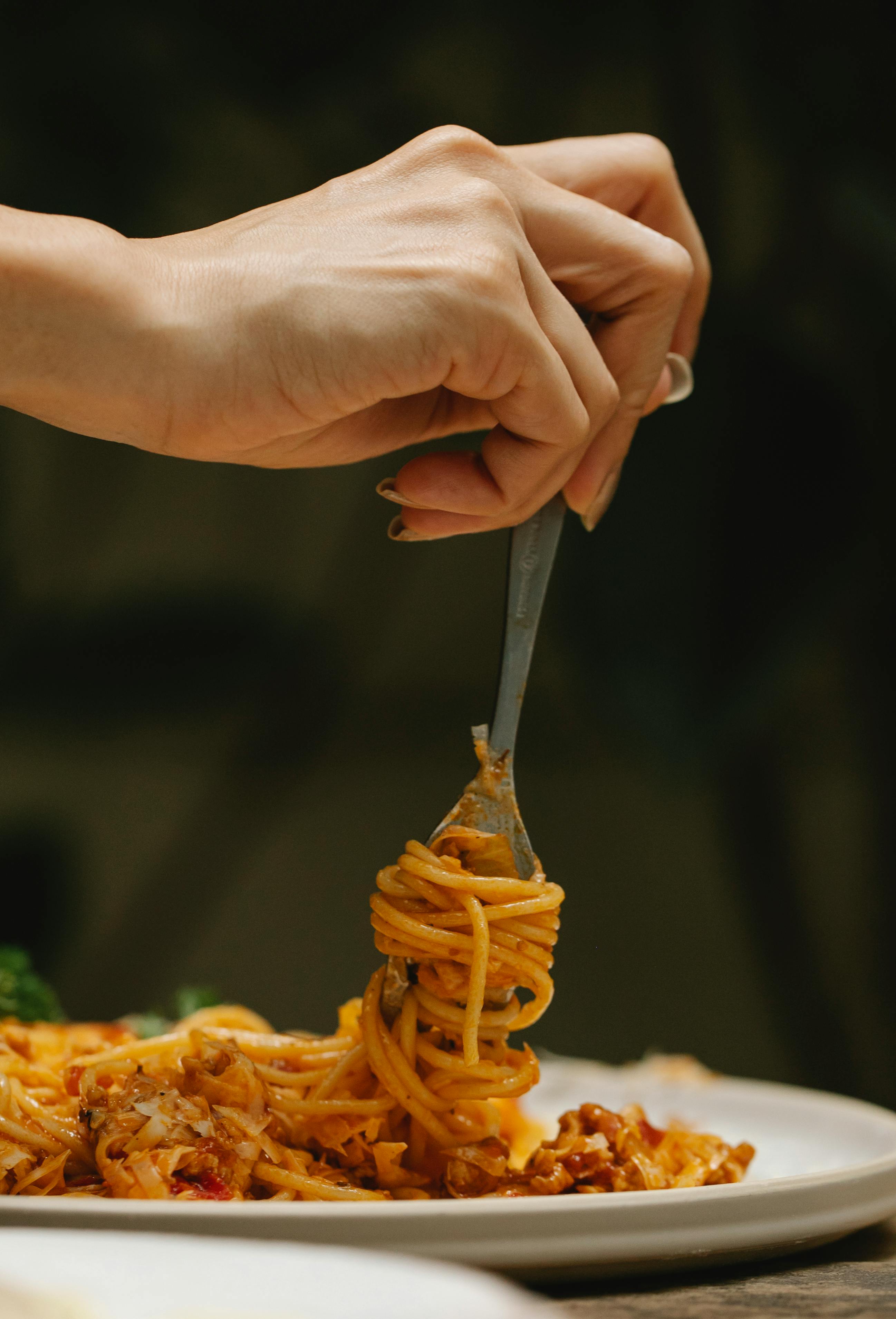 Frau rollt Spaghetti auf Gabel | Quelle: Pexels