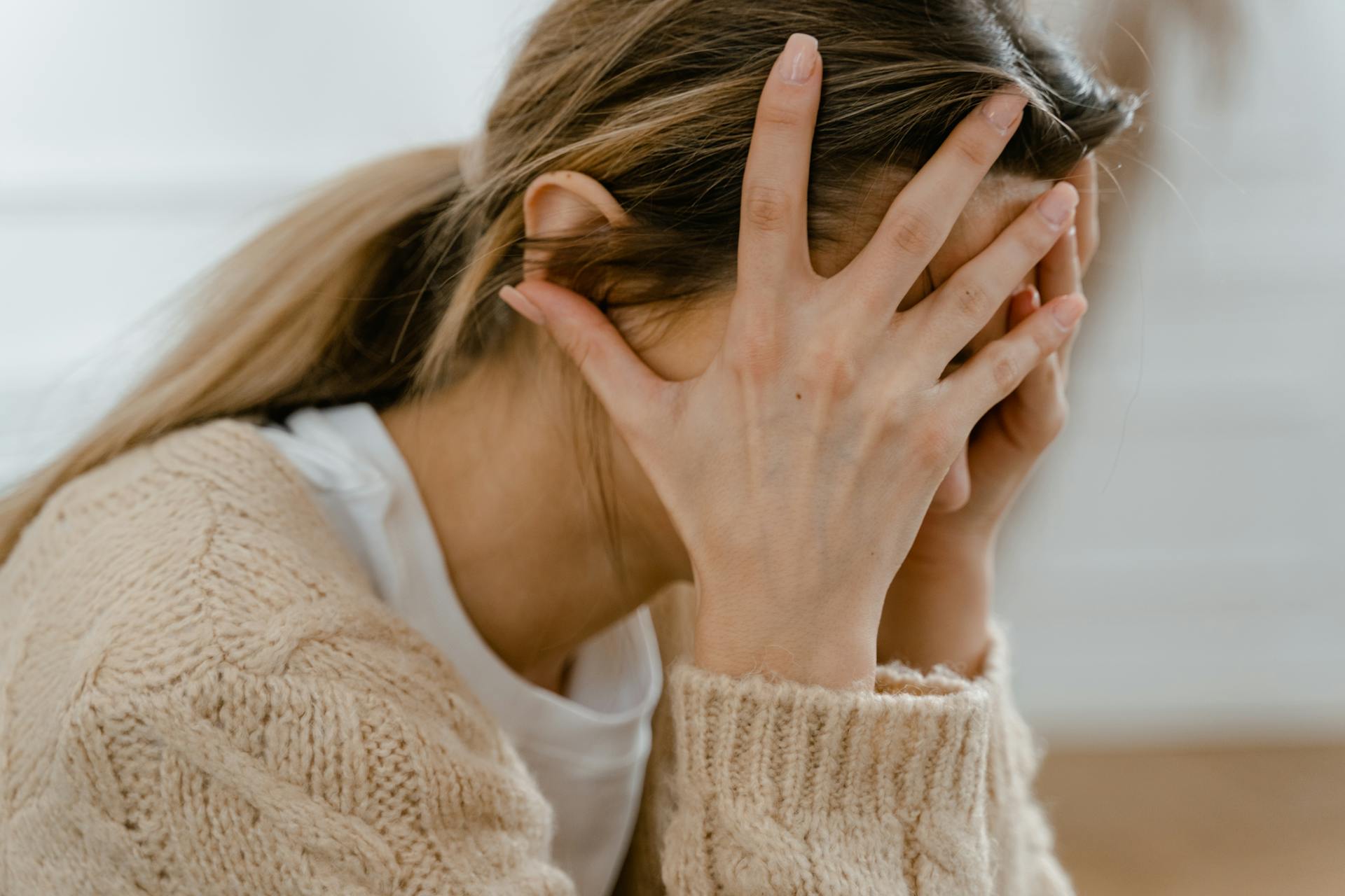 Eine Frau mit dem Kopf in ihren Händen | Quelle: Pexels