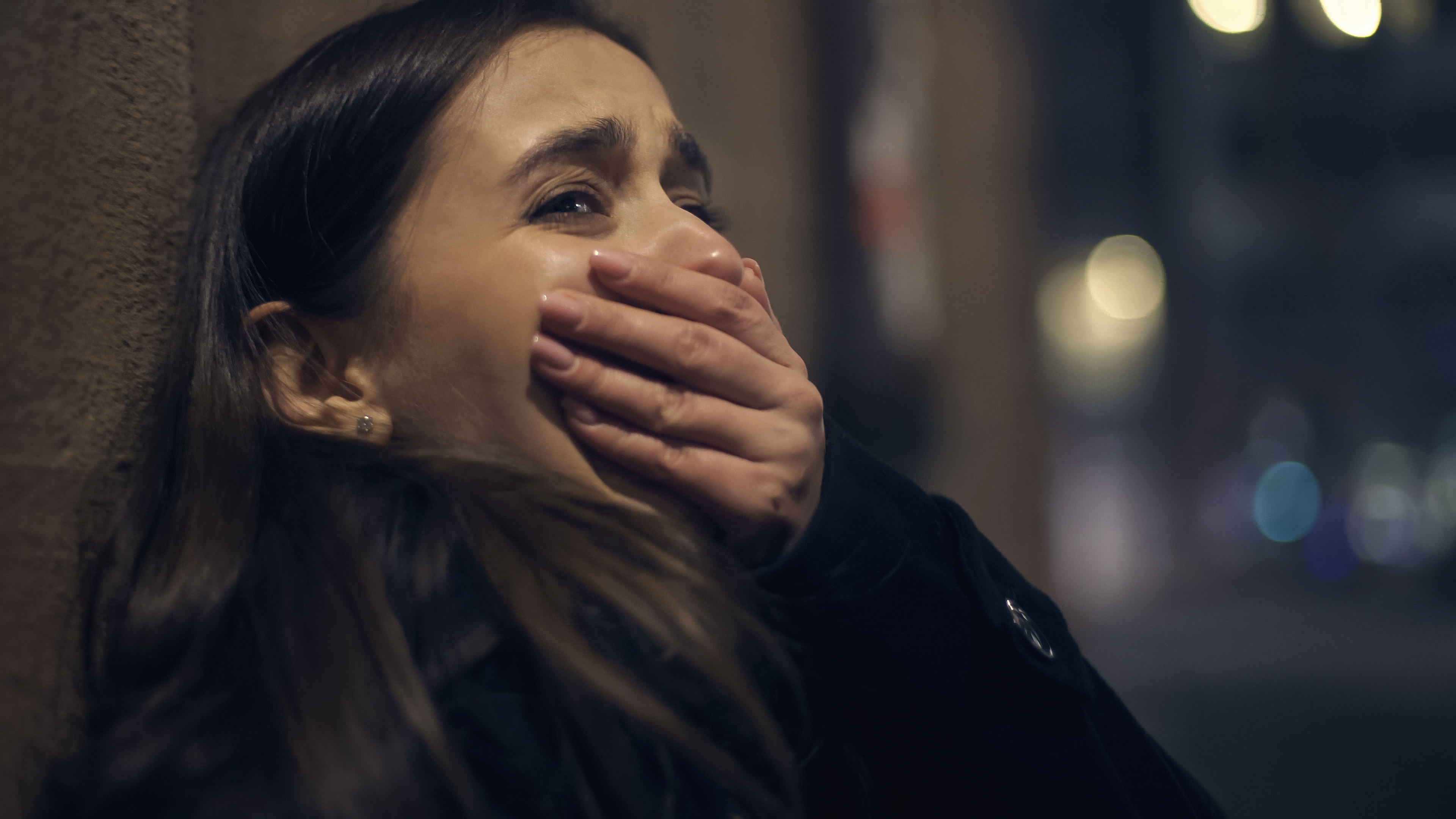 Eine verängstigte, weinende Frau, die sich die Hand vor den Mund hält | Quelle: Shutterstock