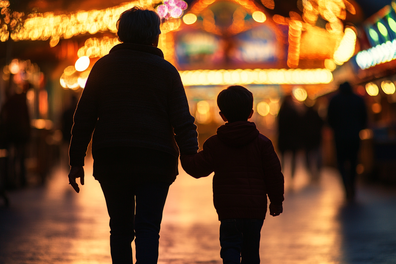 Silhouette eines kleinen Jungen, der mit seiner Oma spazieren geht | Quelle: Midjourney