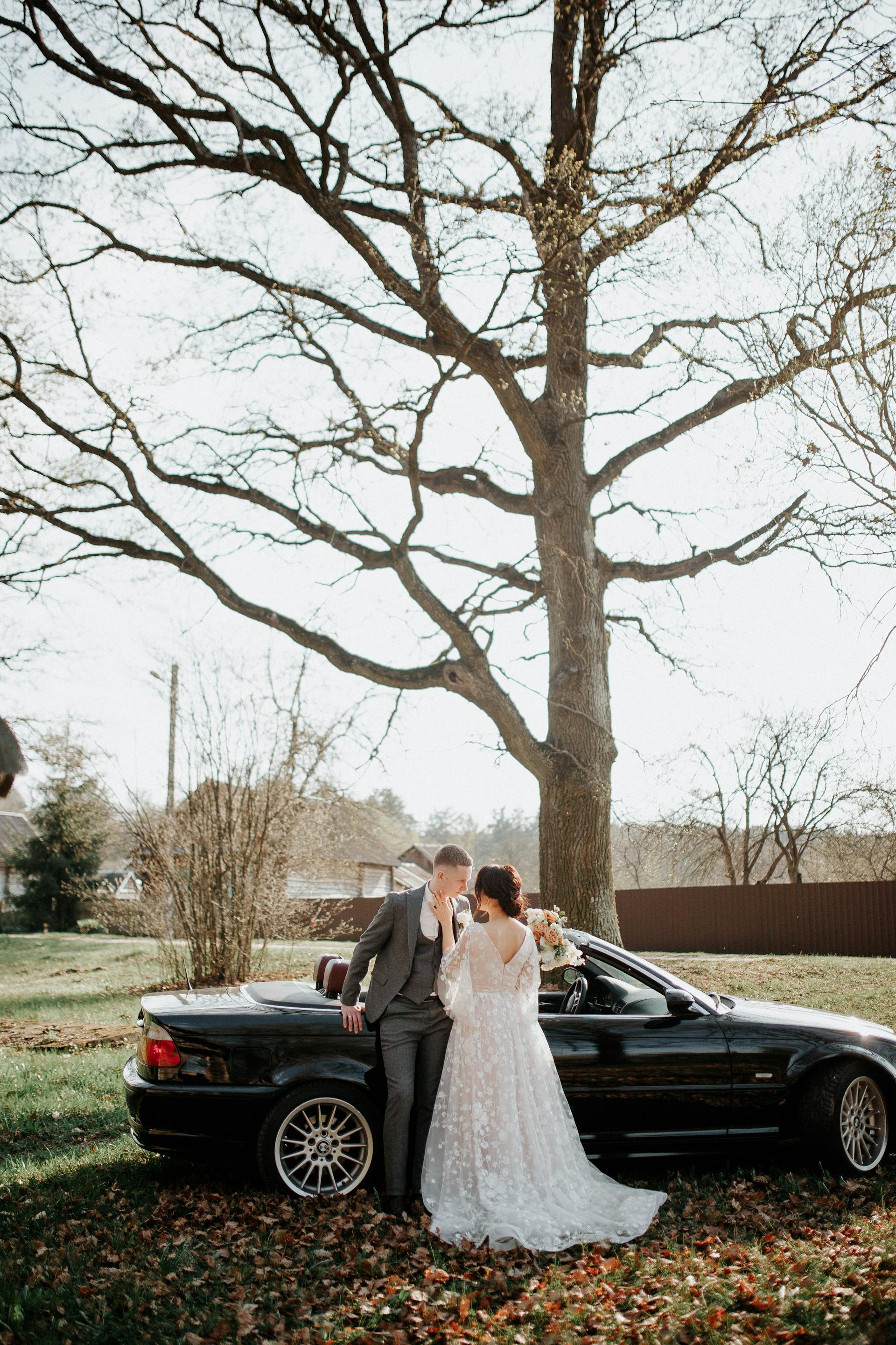 Braut und Bräutigam stehen neben einem Auto | Quelle: Pexels