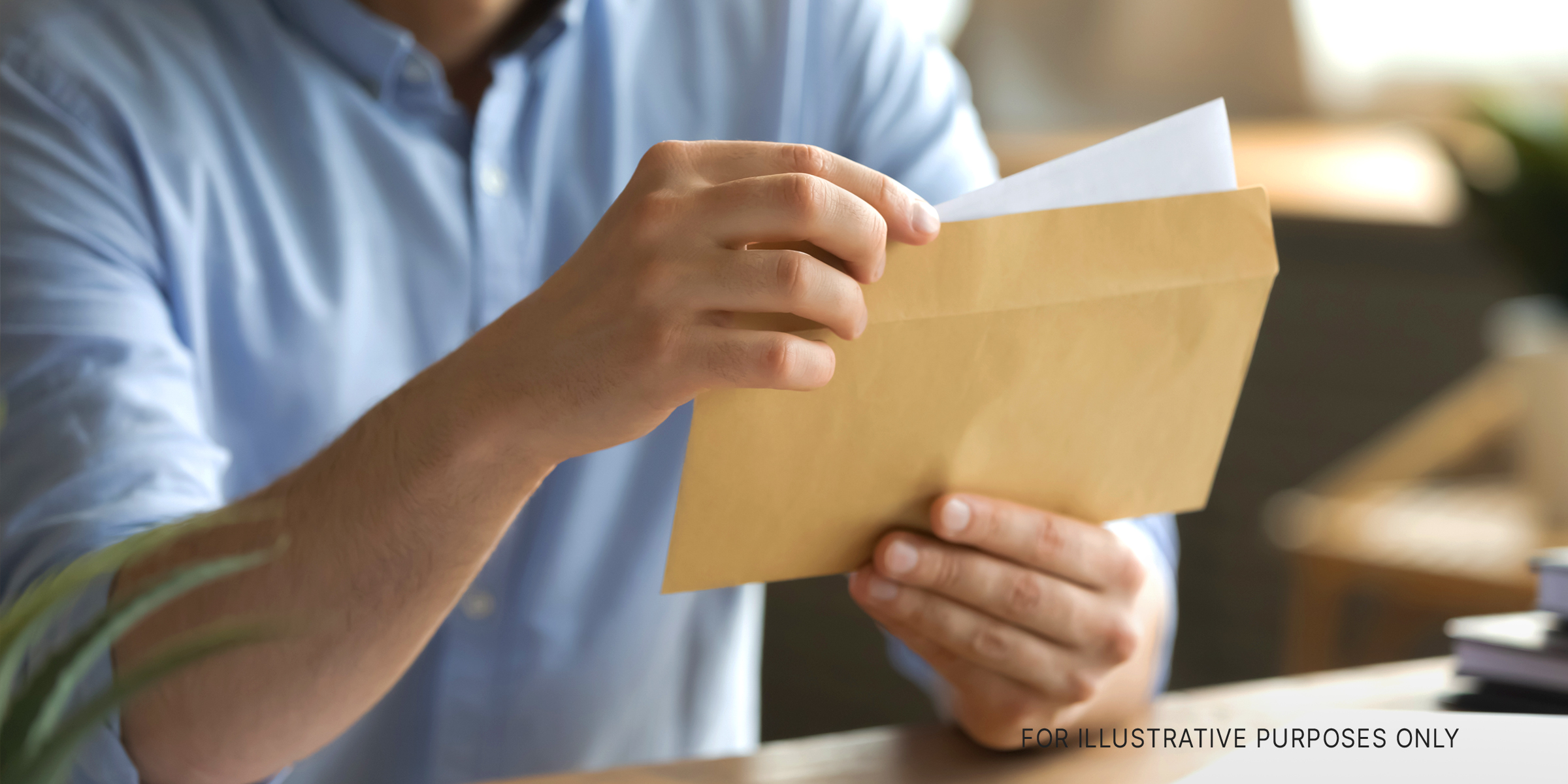 Ein Mann öffnet einen Umschlag und nimmt einen Brief heraus | Quelle: Shutterstock