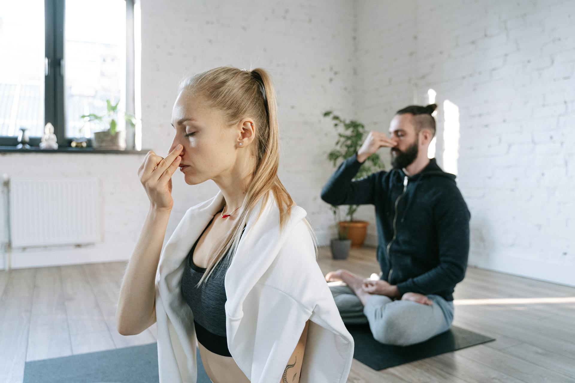 Ein Paar übt Atemübungen während einer ruhigen Yogastunde | Quelle: Pexels