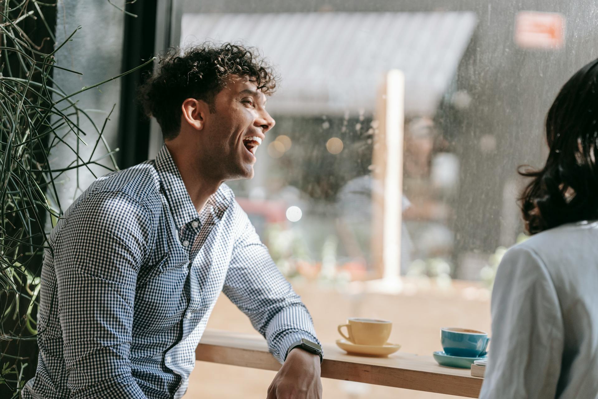 Ein lachender Mann in einem Coffee Shop | Quelle: Pexels