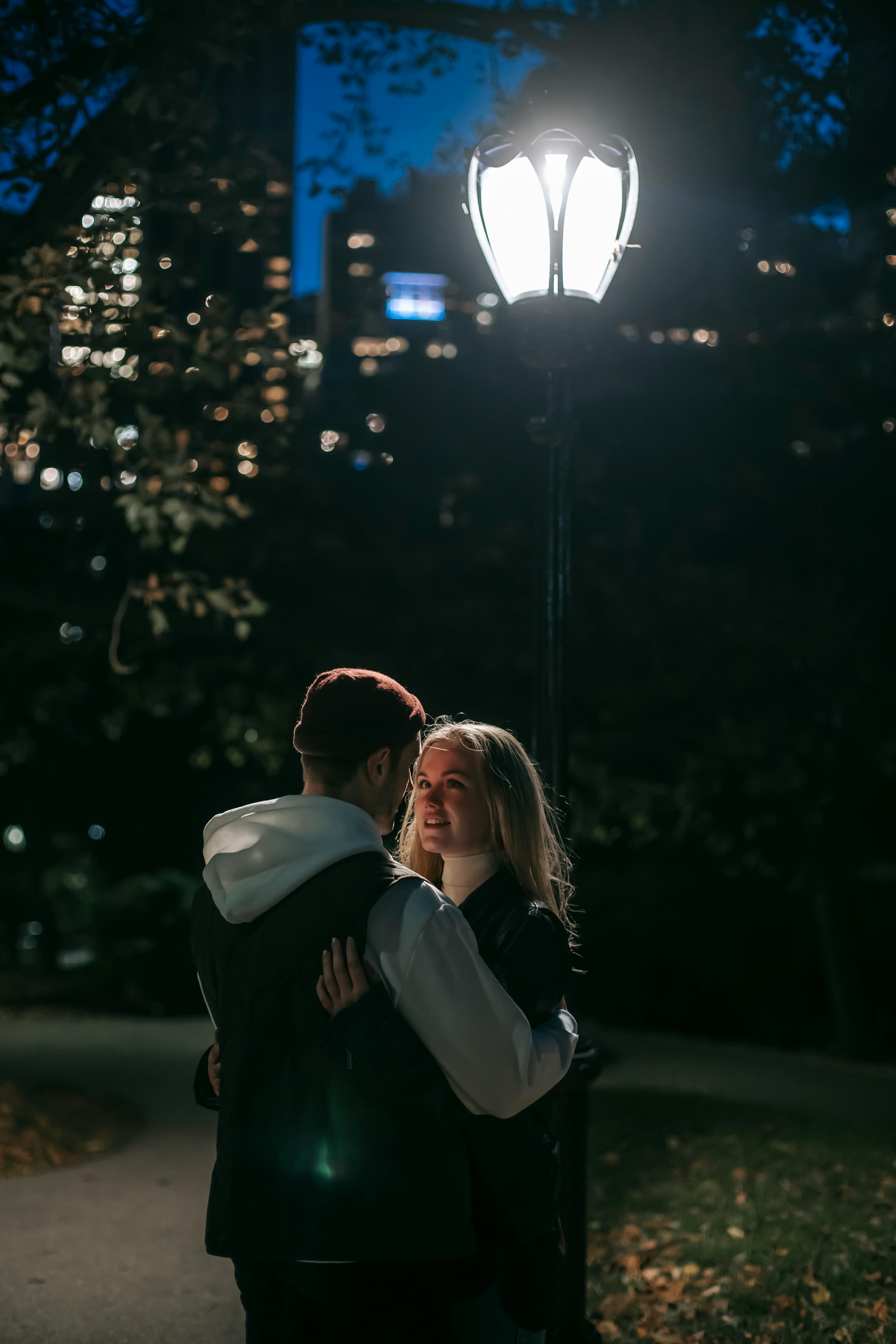 Ein Paar, das sich nachts in einem Park umarmt | Quelle: Pexels
