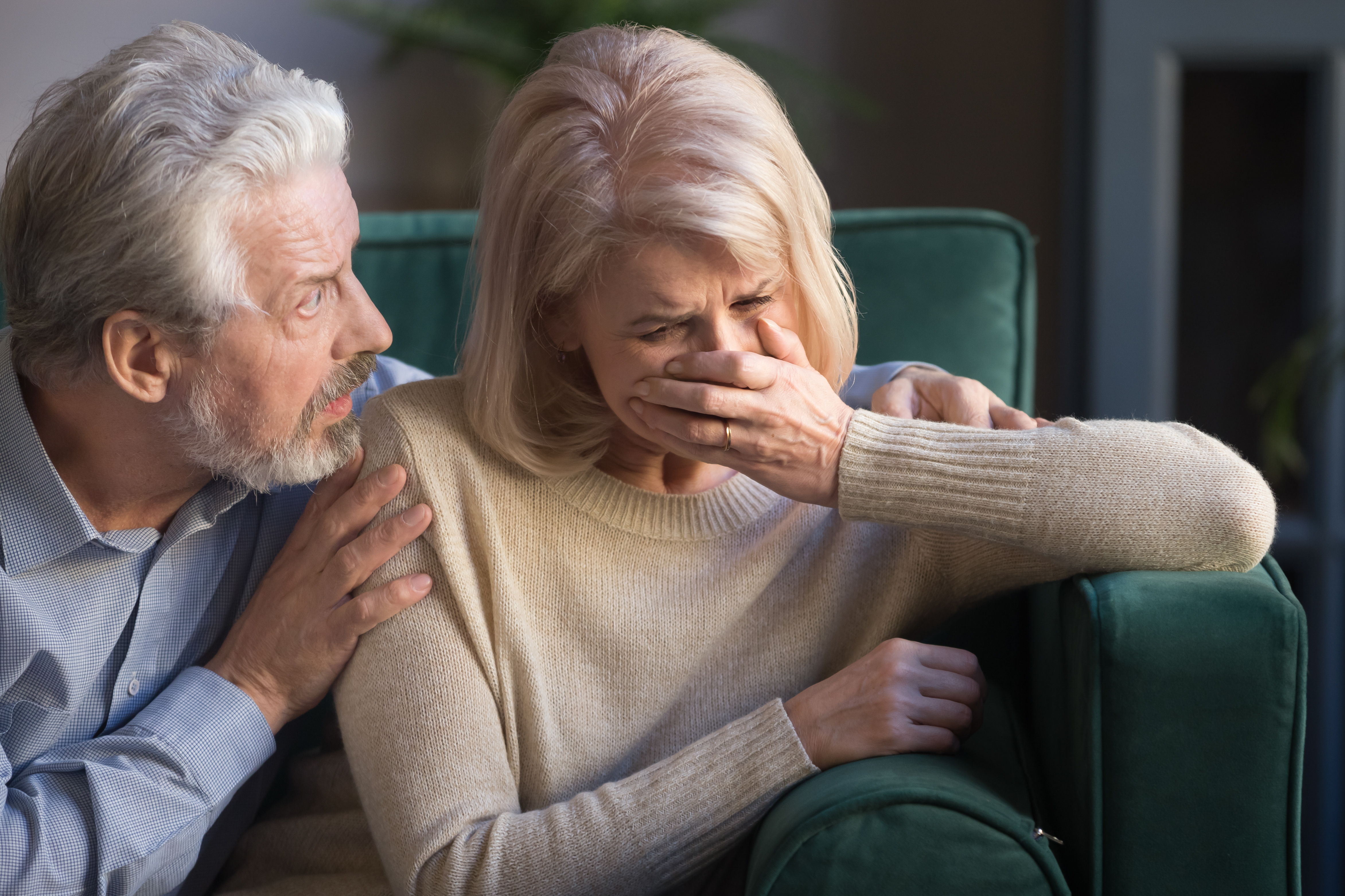 Eine Frau weint, während ihr Mann sie tröstet. | Quelle: Shutterstock