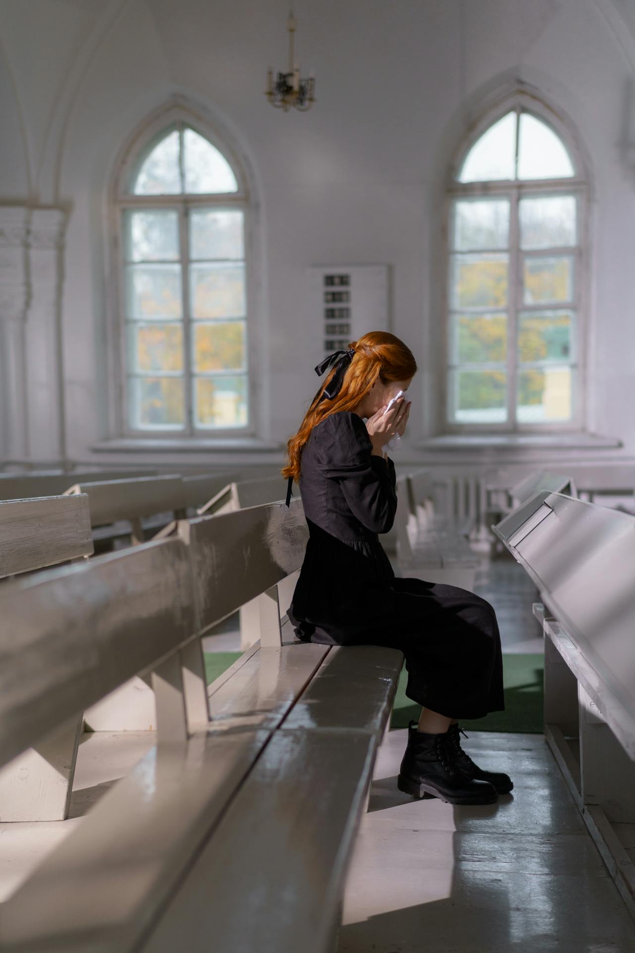 Eine einsame und emotionale Frau, die in der Kirche sitzt und weint | Quelle: Pexels