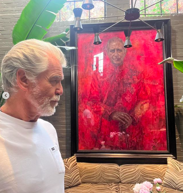 Pierce Brosnan posiert für ein Foto mit dem Porträt von König Charles III, gepostet am 7. Juli 2024 | Quelle: Instagram/piercebrosnanofficial