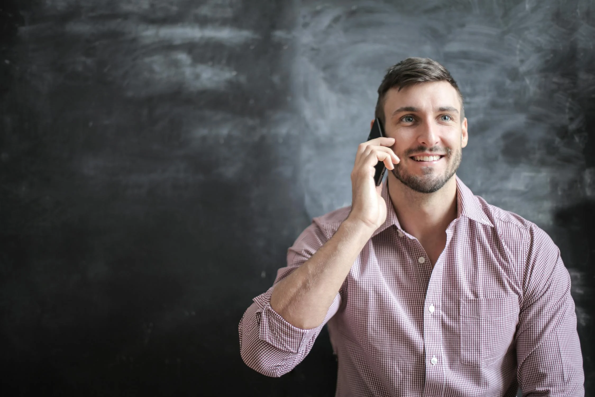 Ein lächelnder Mann, der mit seinem Telefon spricht | Quelle: Pexels