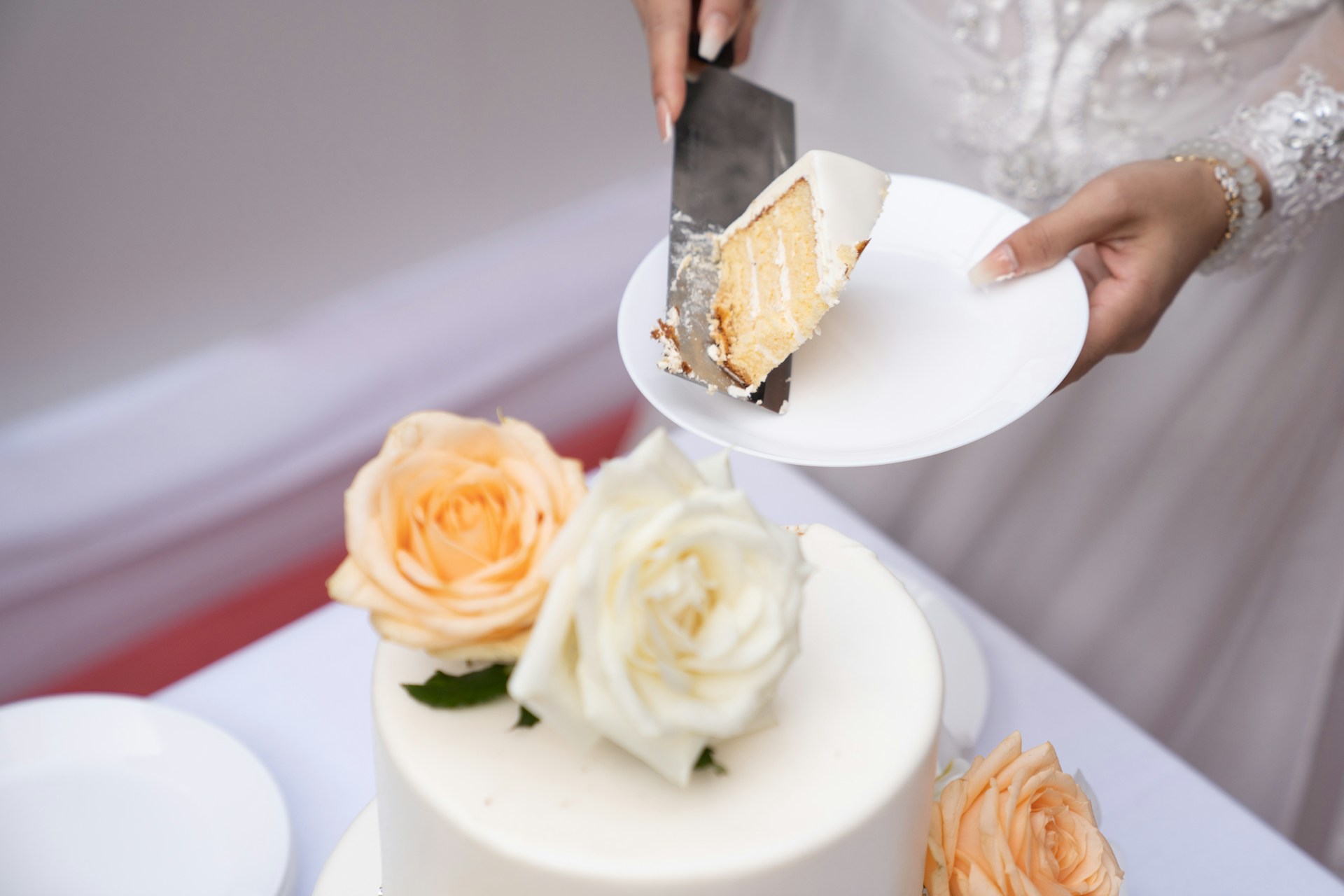Eine Braut hält einen Teller mit Hochzeitstorte | Quelle: Unsplash