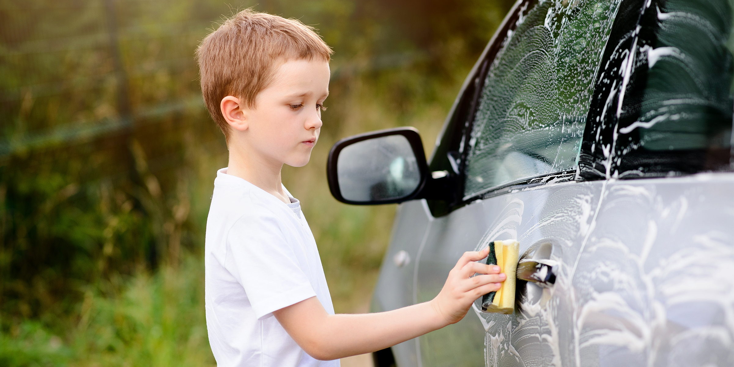 Ein Junge reinigt ein Auto | Quelle: Shutterstock