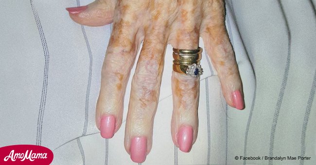 Eine Krankenschwester lackiert einer alten Dame ihre Nägel, sie bemerkt etwas und macht ein Foto davon
