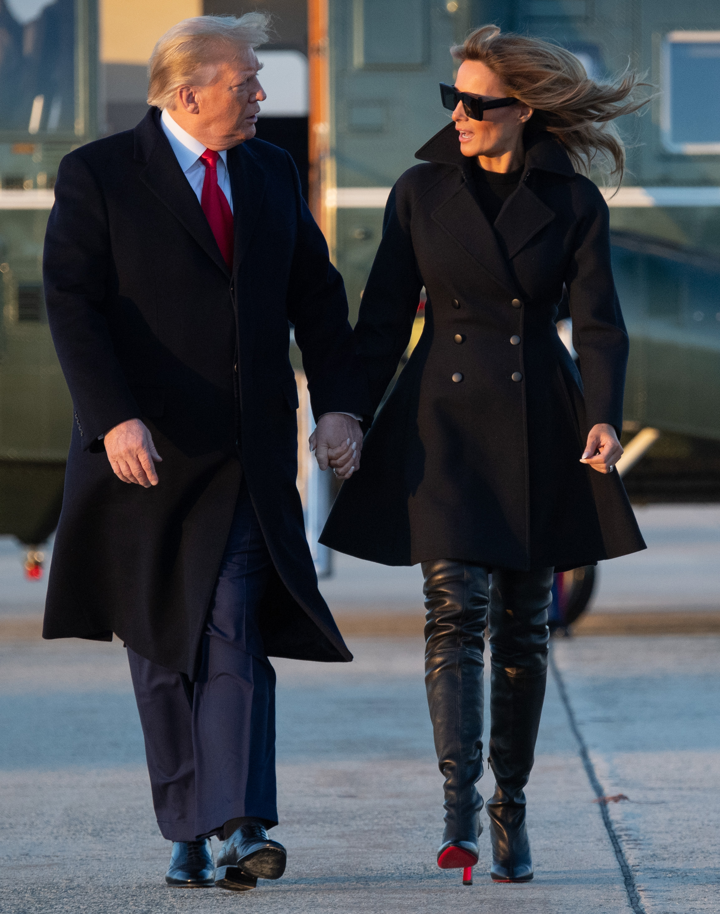 First Lady Melania Trump verlässt am 23. Dezember 2020 die Joint Base Andrews in Maryland, um Weihnachten und Neujahr in Mar-a-Lago zu verbringen. Sie trägt einen komplett schwarzen Zweireiher, dazu schwarze, oberschenkellange Stiletto-Stiefel von Christian Louboutin aus Leder mit himmelhohen Absätzen und den charakteristischen roten Sohlen.