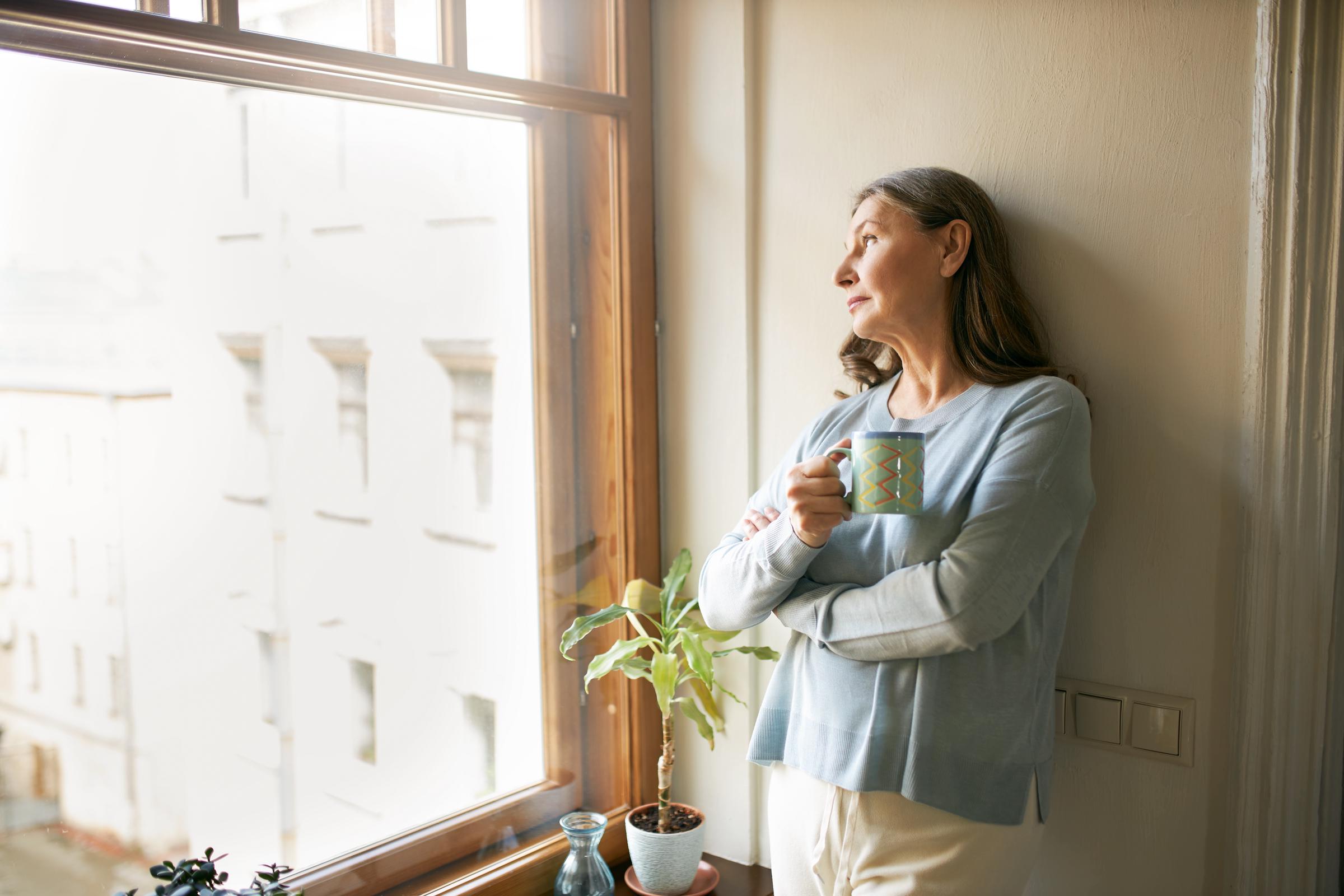 Eine ältere Frau am Fenster | Quelle: Freepik