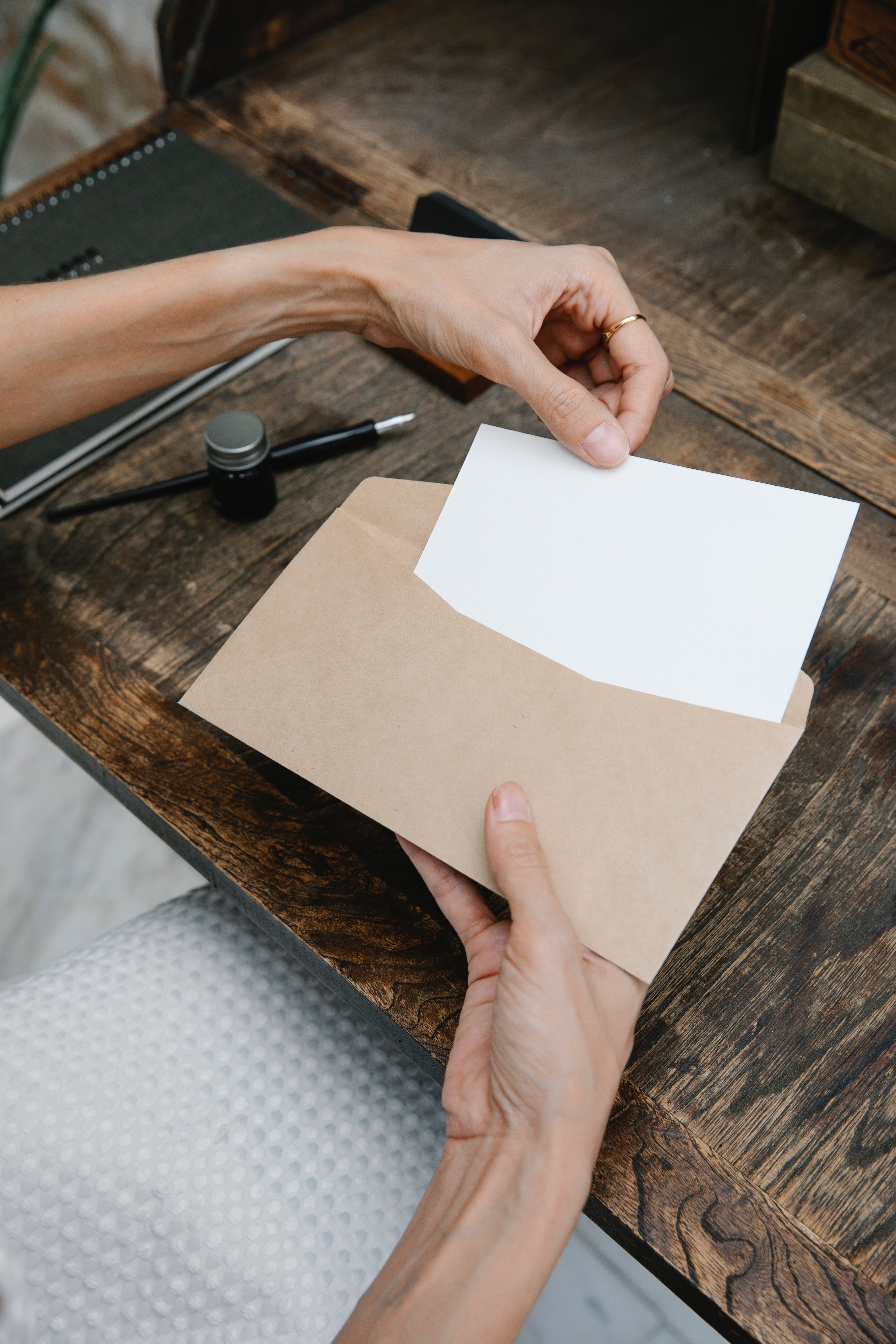 Eine Frau legt ein leeres Papier in einen Umschlag | Quelle: Pexels